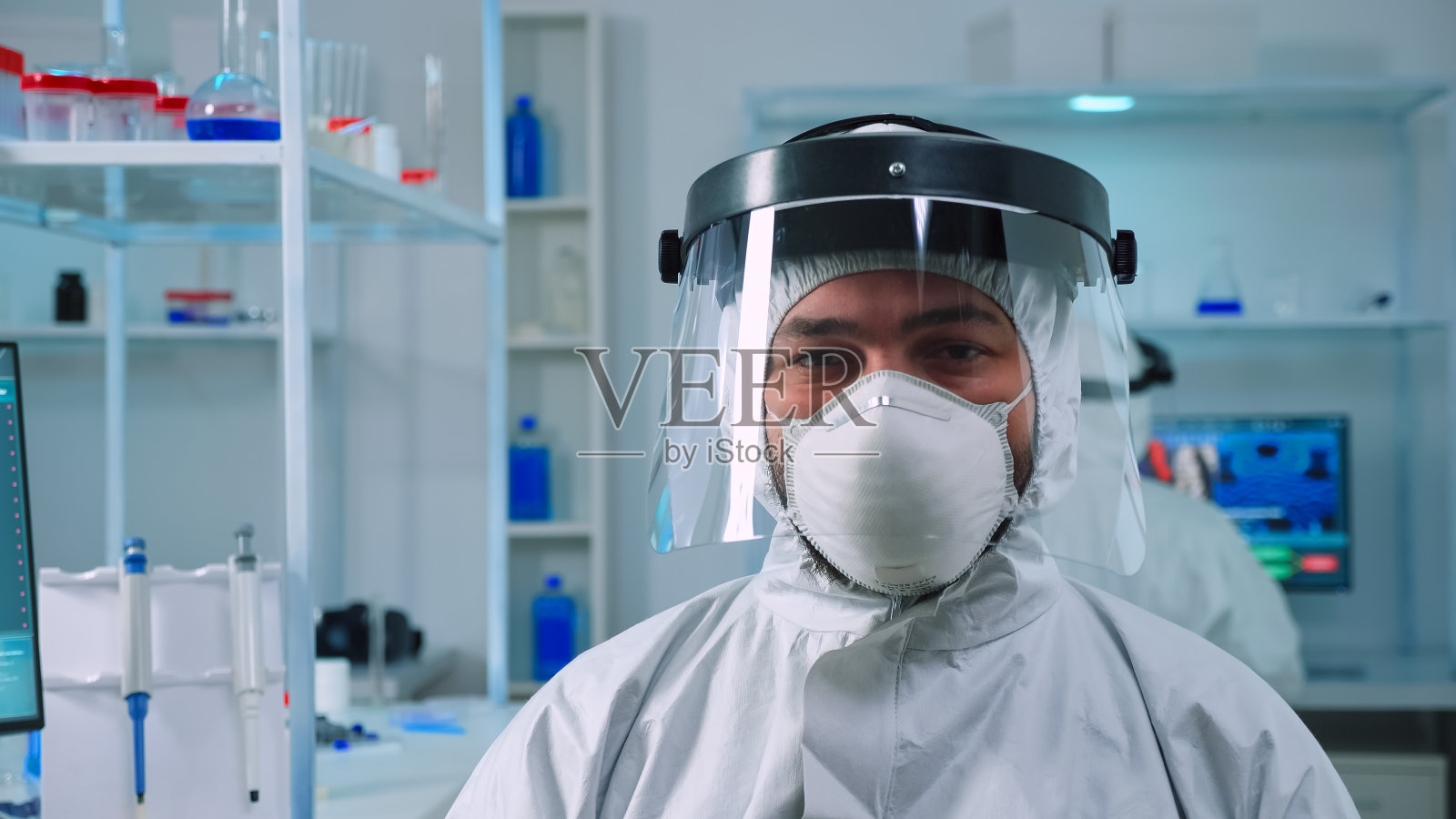 疲惫的科学家穿着防护服看着相机的肖像照片摄影图片