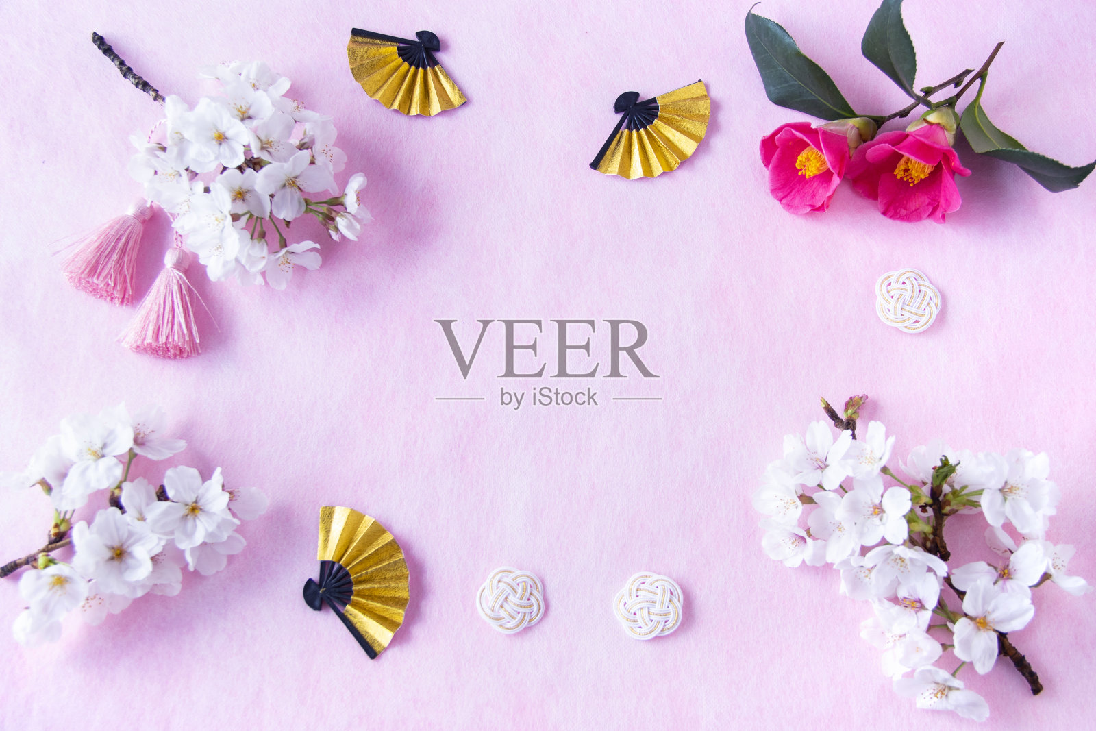 日本新年的形象。樱花，山茶花，金扇，木薯和流苏。粉红色的washi背景。照片摄影图片