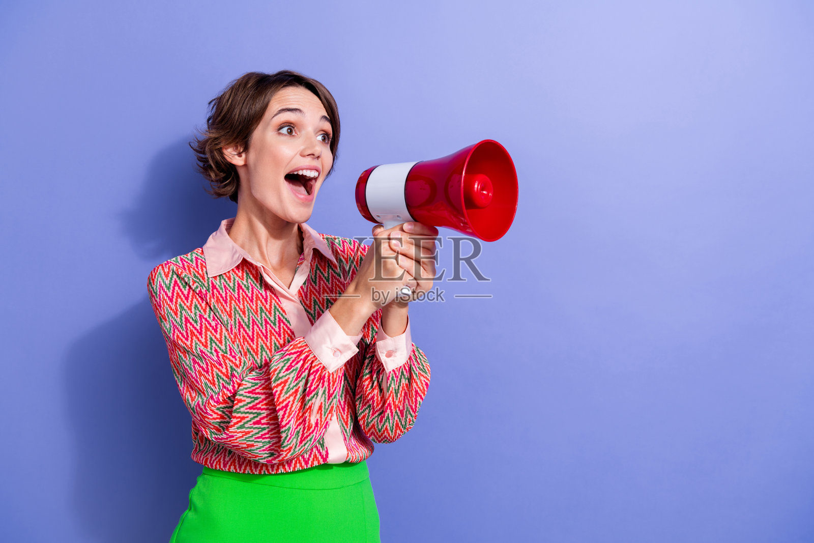 漂亮的年轻女孩的照片肖像拿着扩音器宣布销售穿着时尚的印花服装孤立的紫色背景照片摄影图片