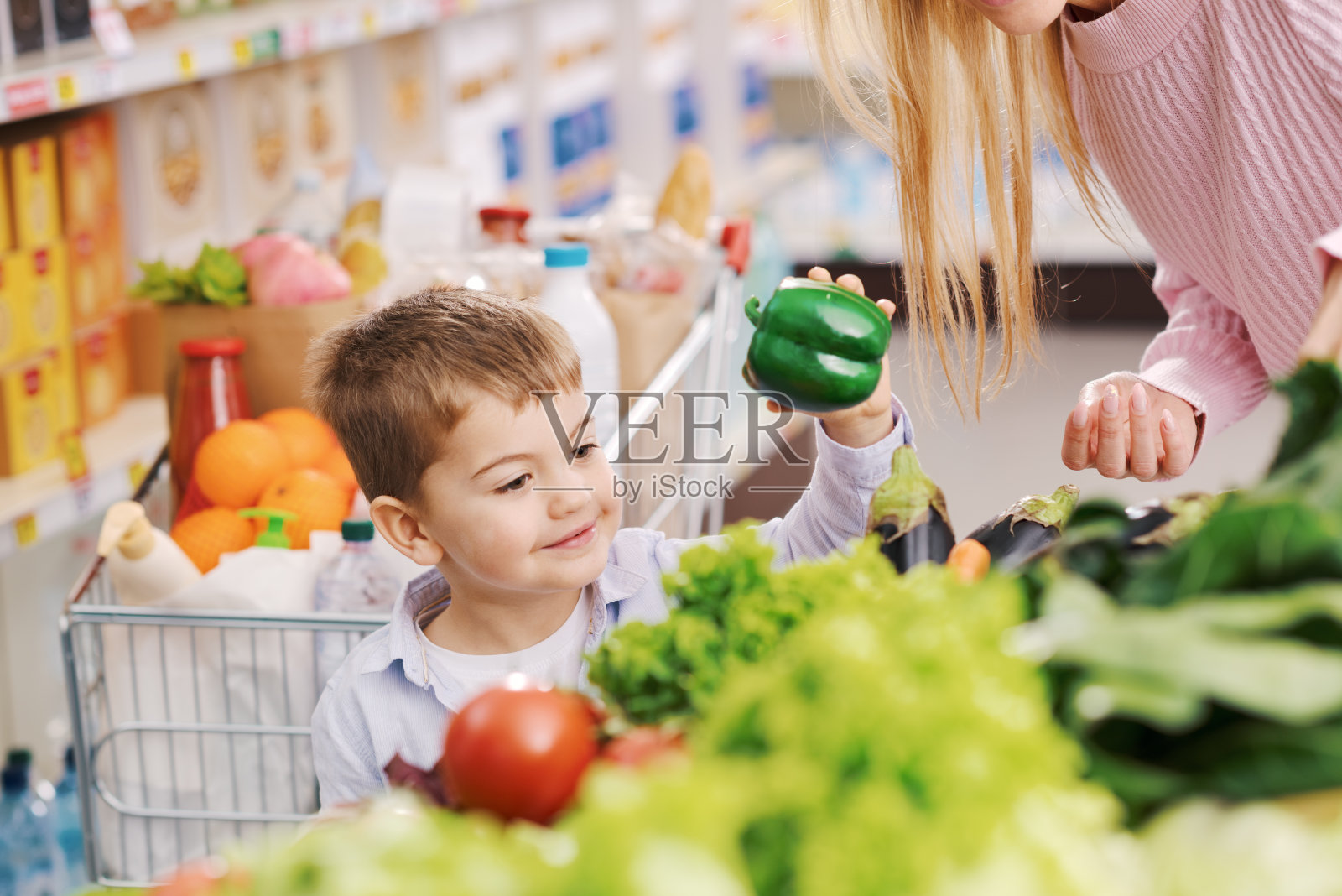 慈祥的母亲和孩子一起去杂货店买东西照片摄影图片