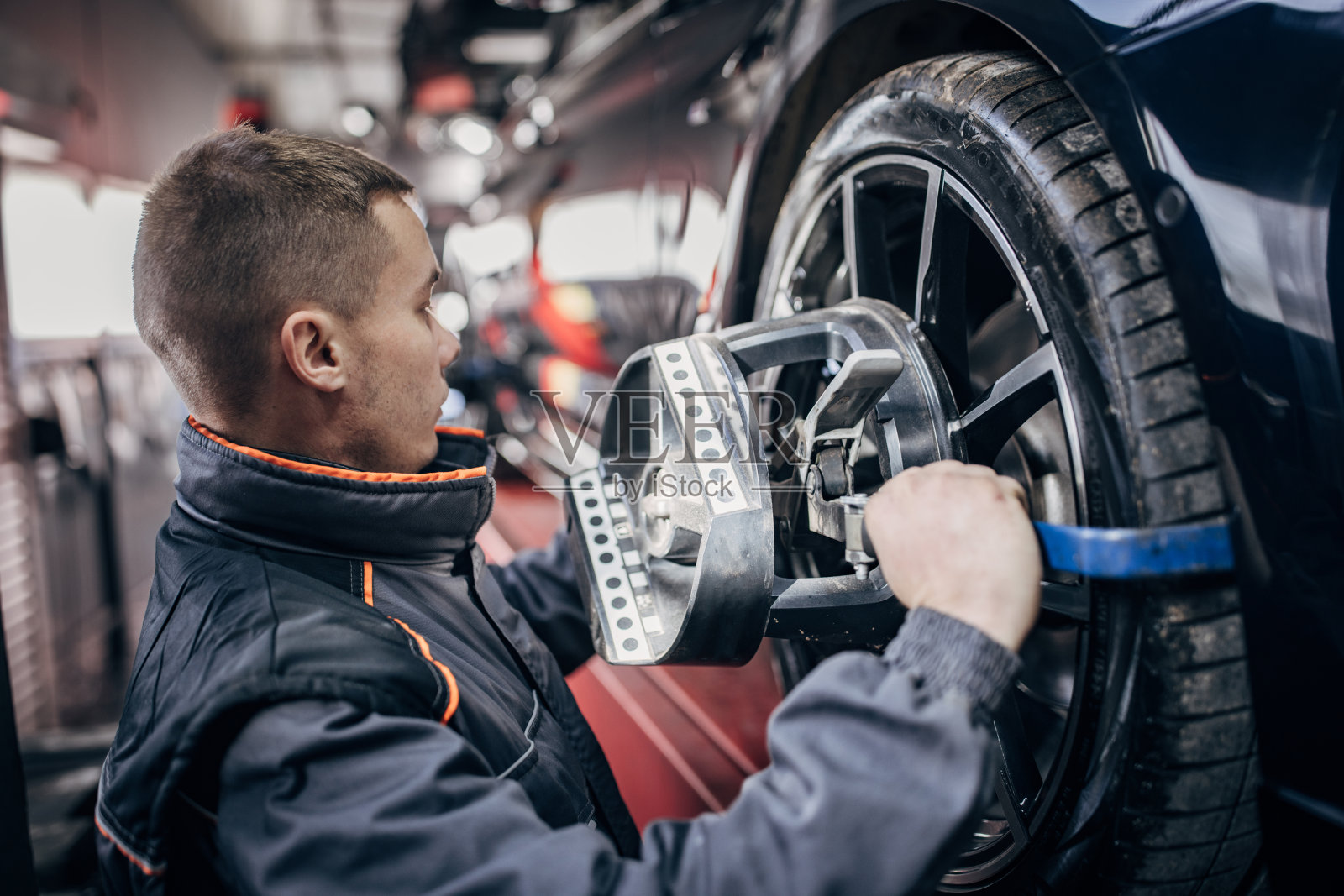 机械师将车轮对准设备安装在汽车车轮上照片摄影图片