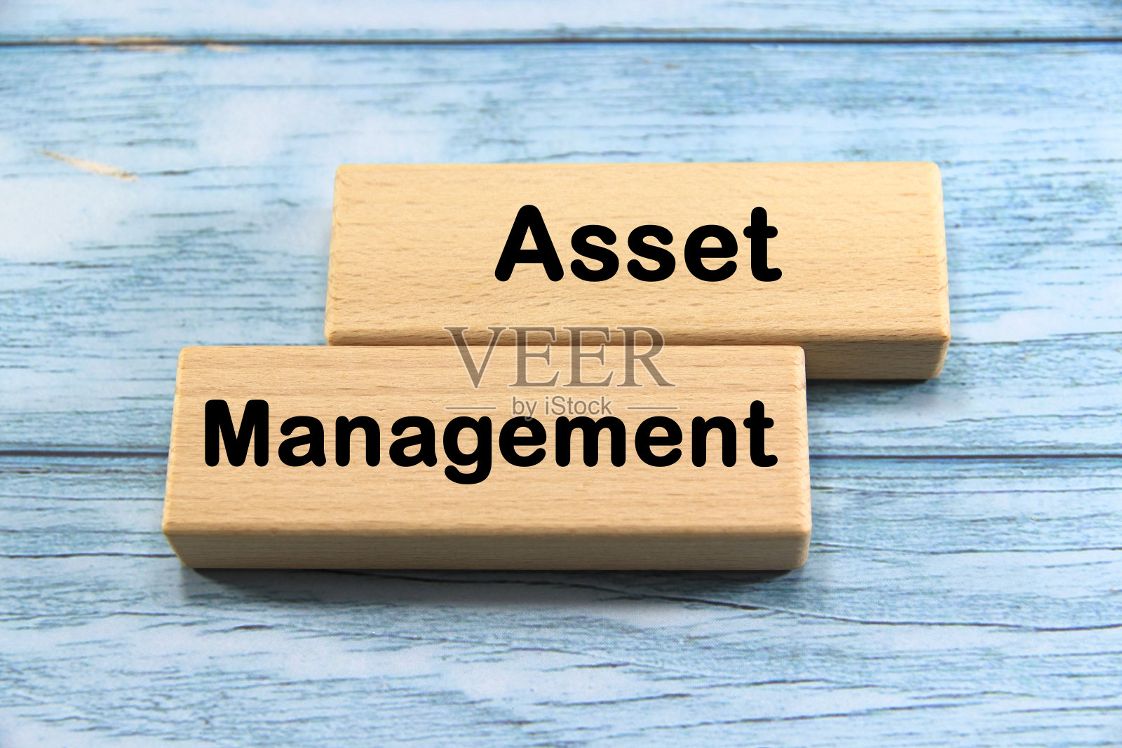 资产管理文本或消息短词英文字母木制立方体块与蓝色复古背景。副本的空间。照片摄影图片