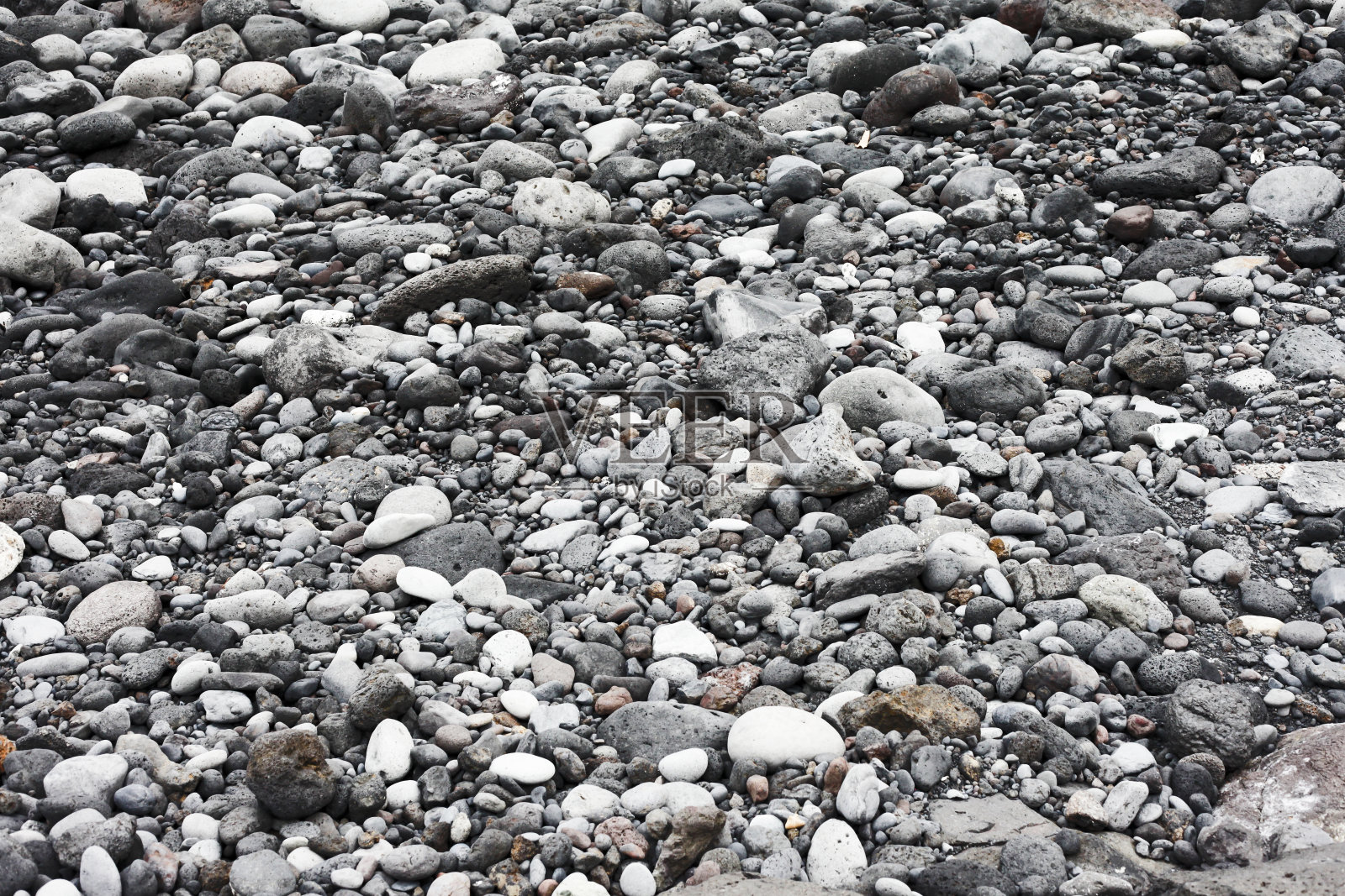 火山岩纹理。加那利群岛的岩石海滩。特内里费黑海滩。小石头背景。照片摄影图片