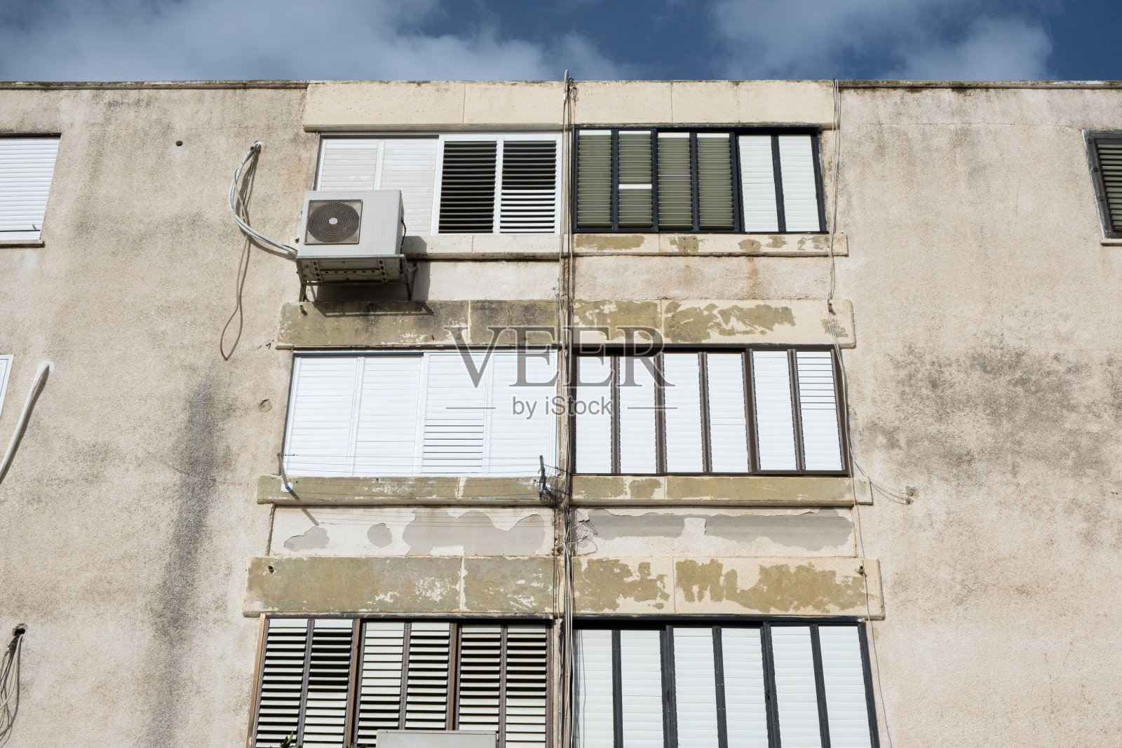 以色列典型的老式建筑。墙上挂着空调的老房子。照片摄影图片