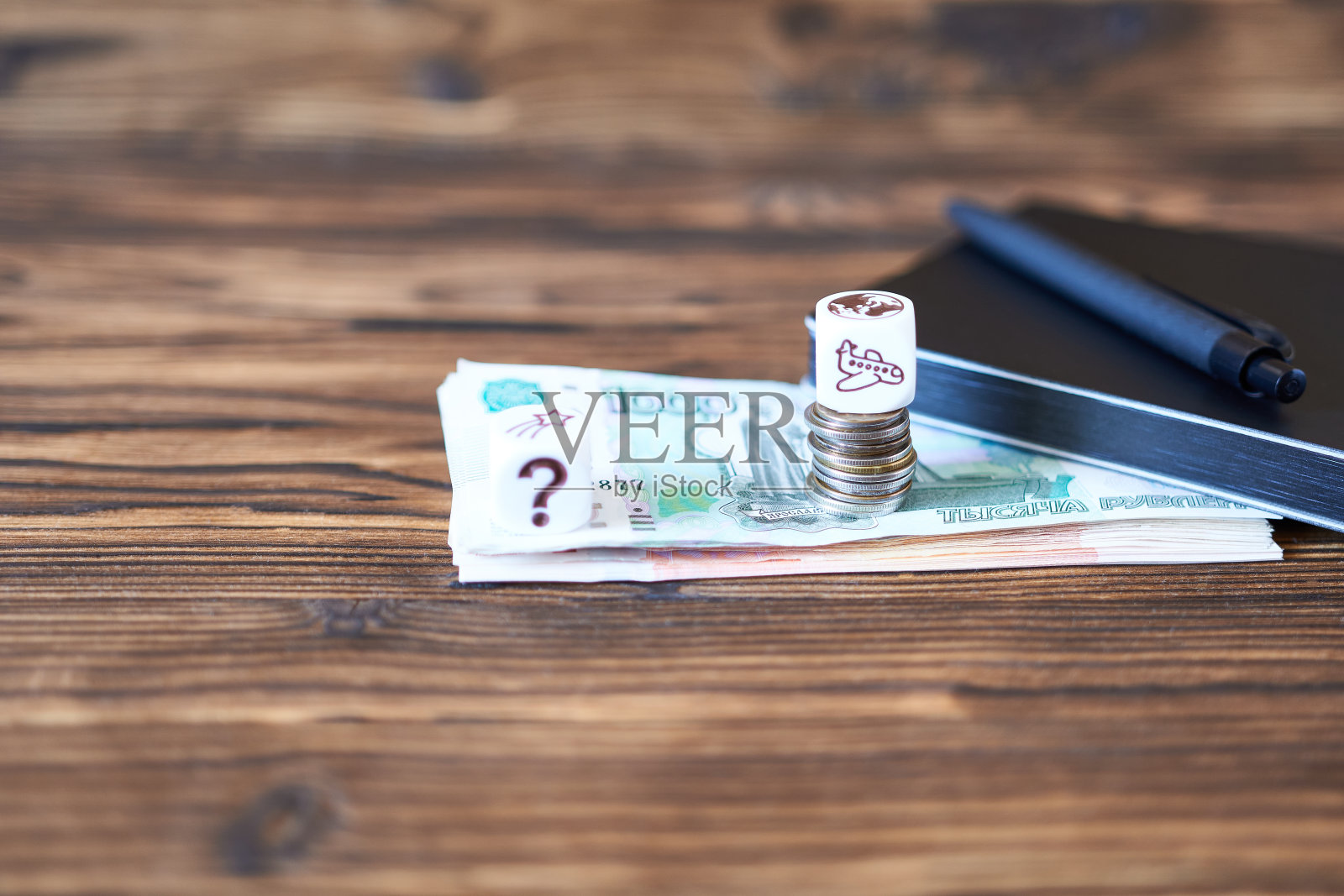 钱、便笺簿和笔放在一张木桌上。这个概念是商业，规划。照片摄影图片