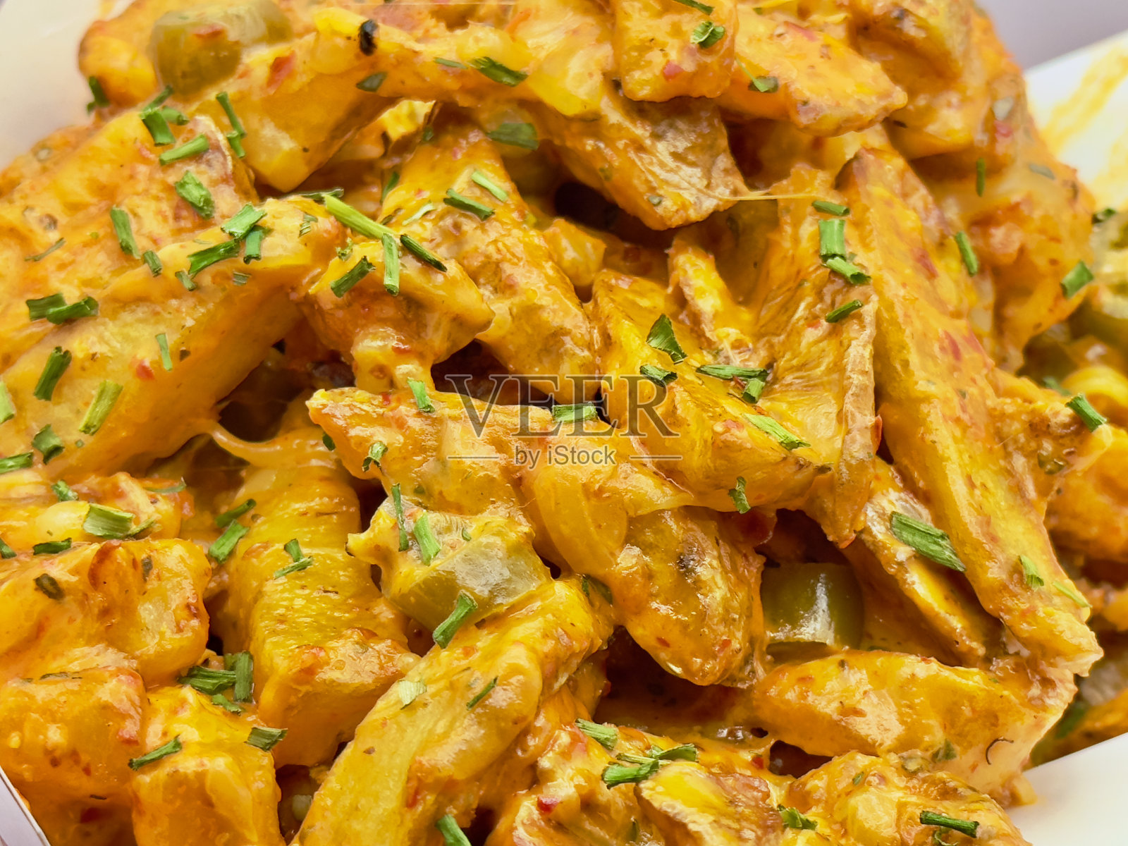 柳条篮子里装满了煮熟的土豆，上面覆盖着融化的奶酪照片摄影图片