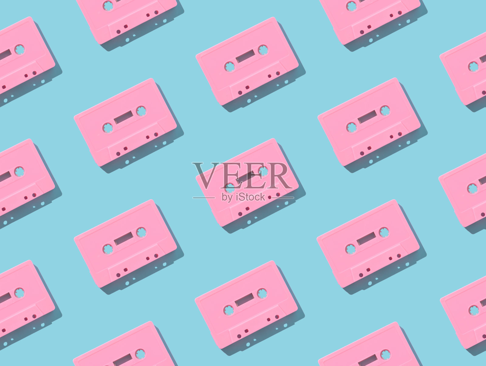 图案制成的复古粉红色的音频磁带浅蓝色的背景。复古科技的创意理念。80的审美。老式音频盒式磁带模式的想法。复古的怀旧。平的。照片摄影图片