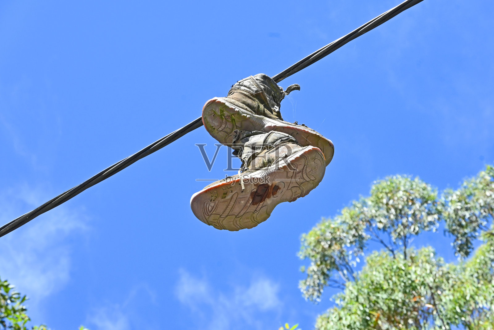 旧靴子挂在铁丝上照片摄影图片