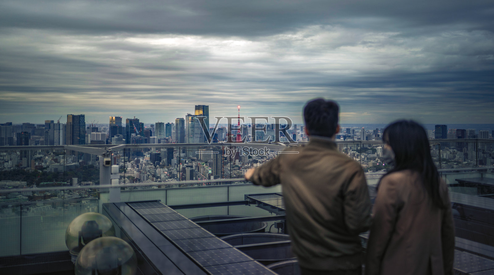 一起在东京的黄昏:一对夫妇凝视城市的灯光照片摄影图片