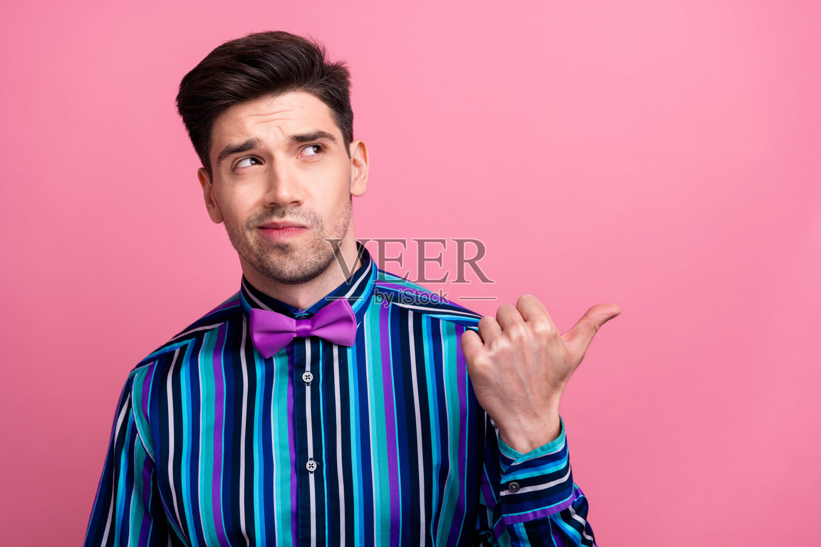 照片的头脑有吸引力的家伙看直接手指空的空间头脑风暴犹豫孤立在粉红色的背景照片摄影图片