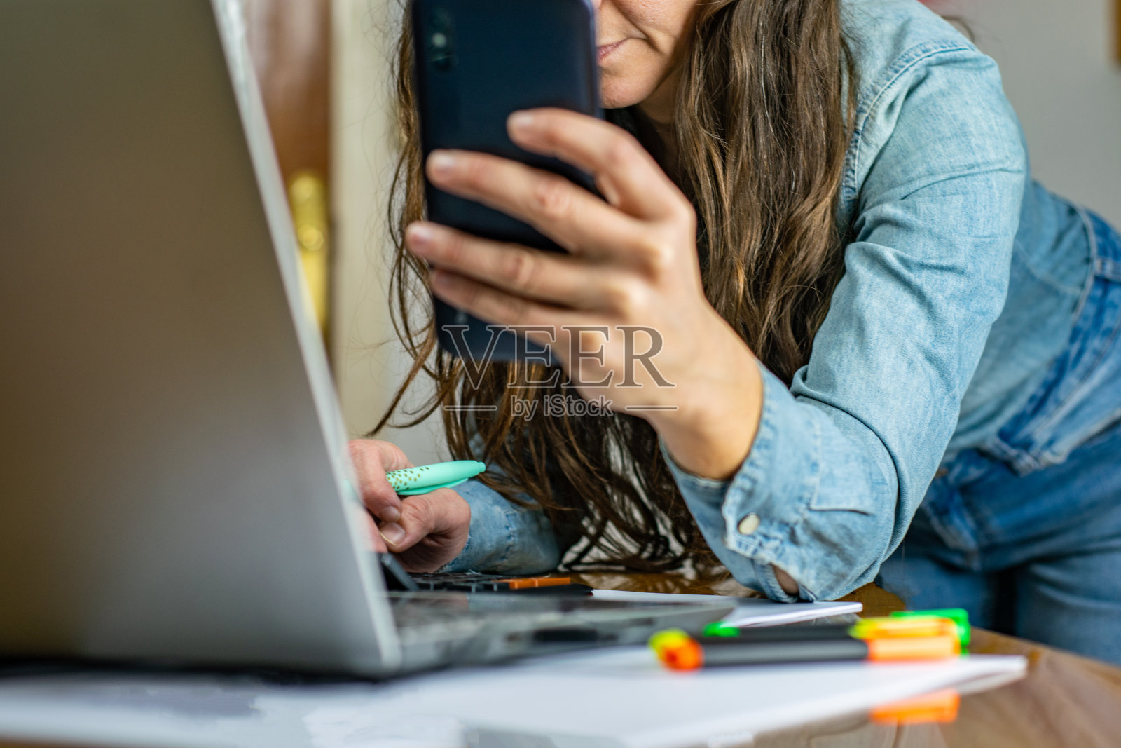 妇女手持银行卡，用手机与笔记本电脑进行网上交易。远程办公支付概念，金融科技复制空间照片摄影图片