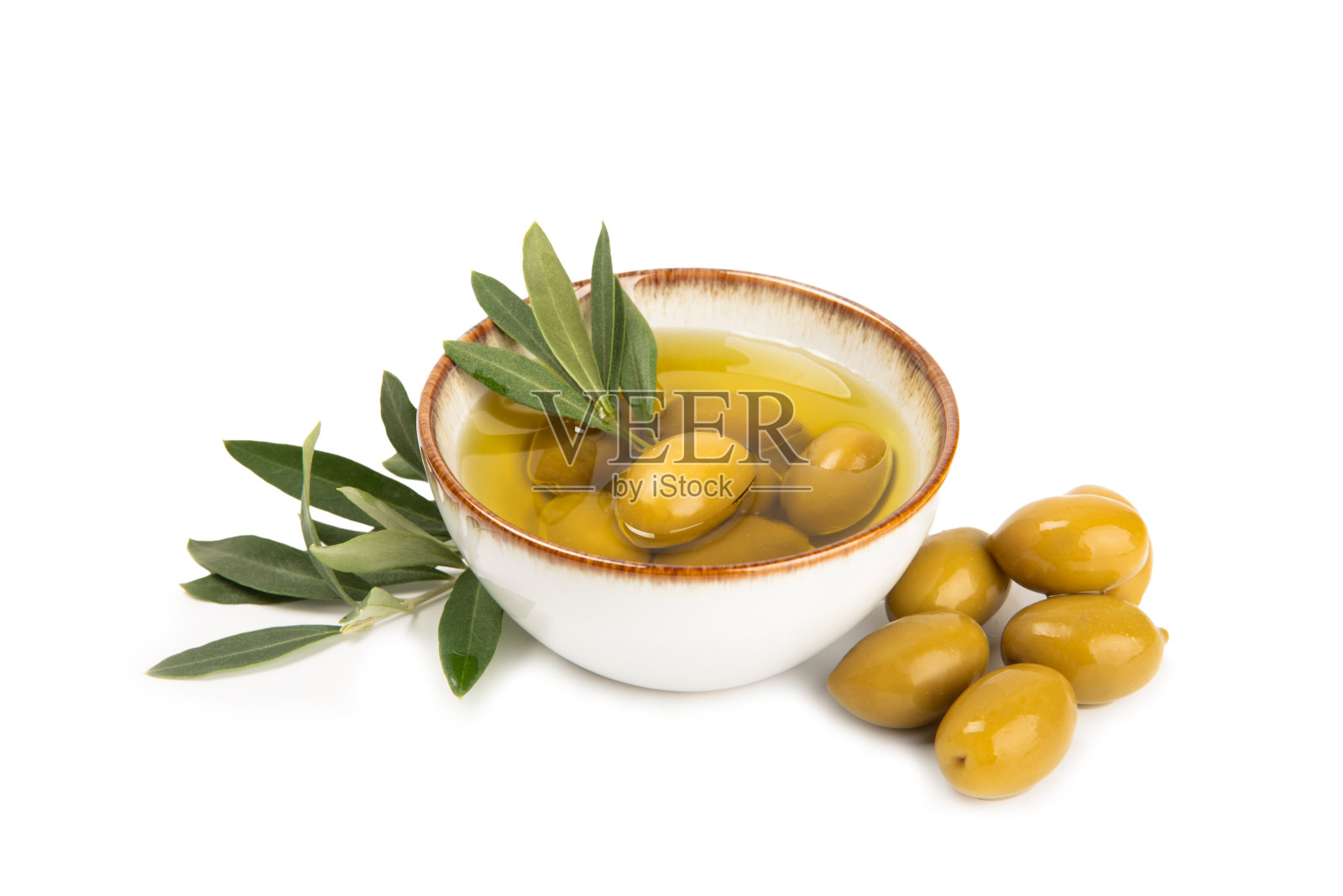 一碗新鲜的橄榄油和橄榄，在白色的背景上孤立的叶子。玻璃碗里装着美味的橄榄油。橄榄油瓶。照片摄影图片
