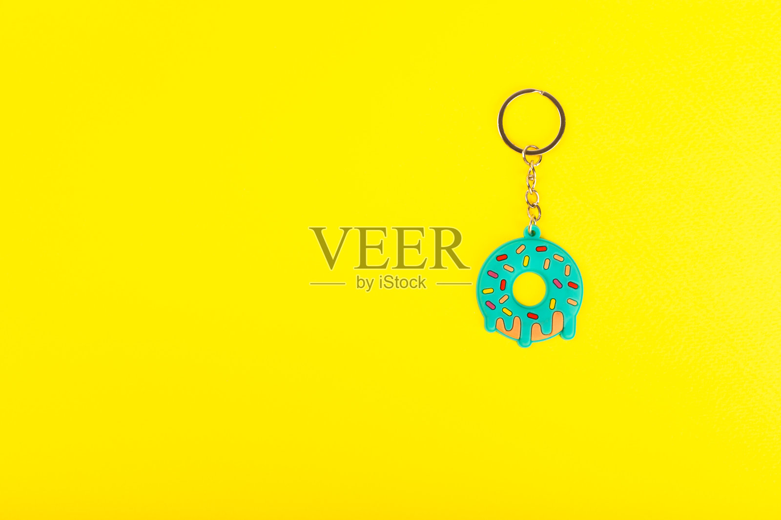 钥匙扣的形状与一个钥匙圈在一个黄色的背景。房地产和搬家或租房的概念。购买房产。模型钥匙扣。副本的空间。照片摄影图片