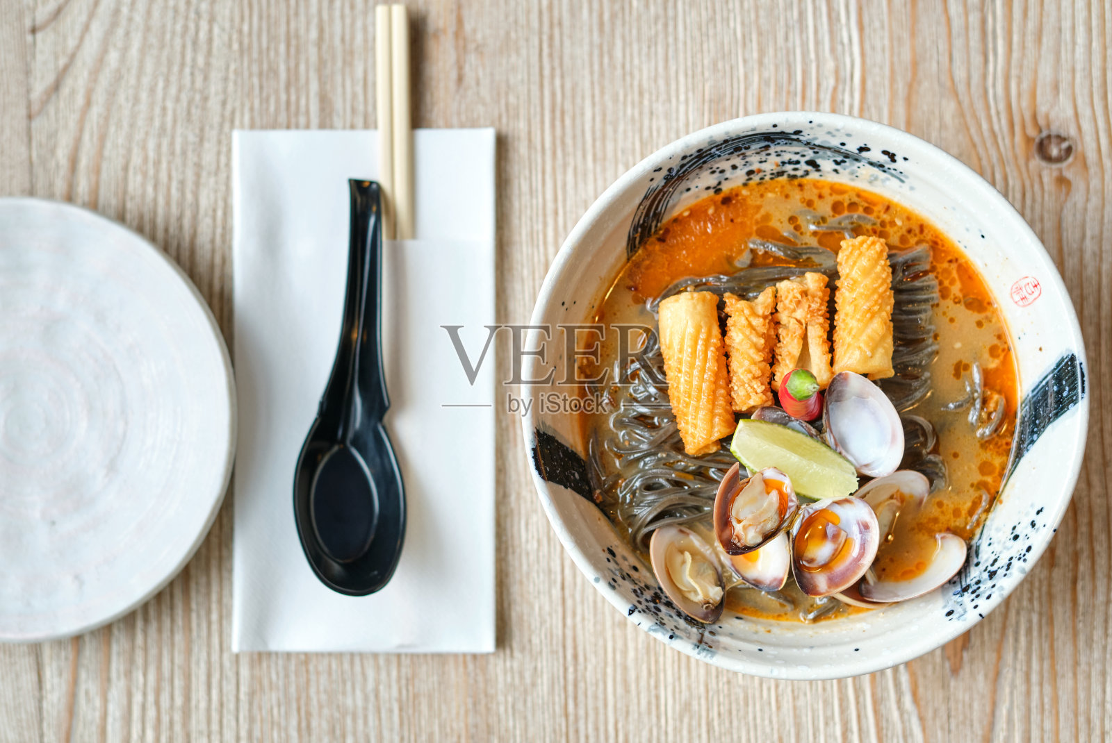 荞麦汤配贝类和脆皮鸡皮近勺照片摄影图片