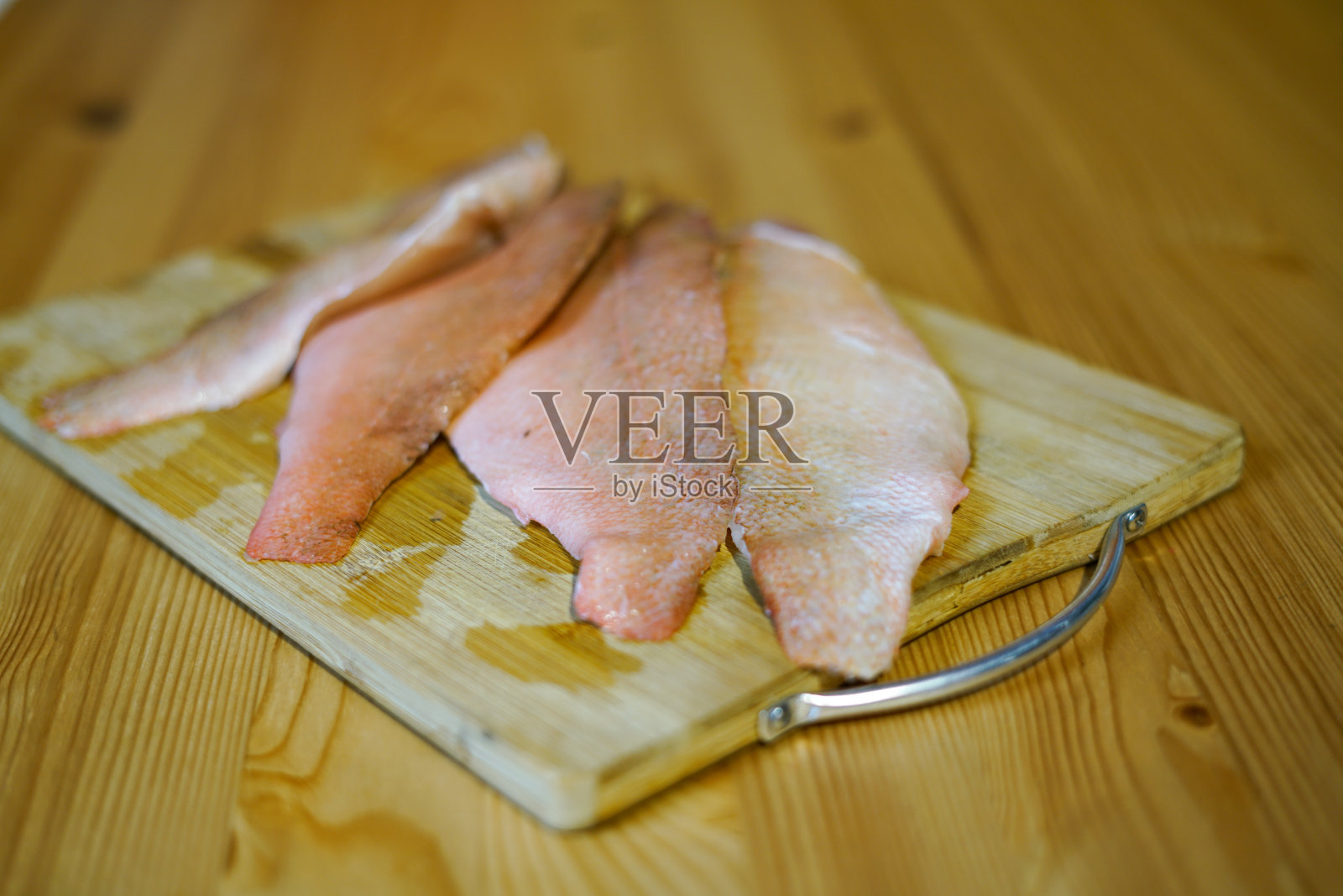 在木板上准备红鱼。照片摄影图片