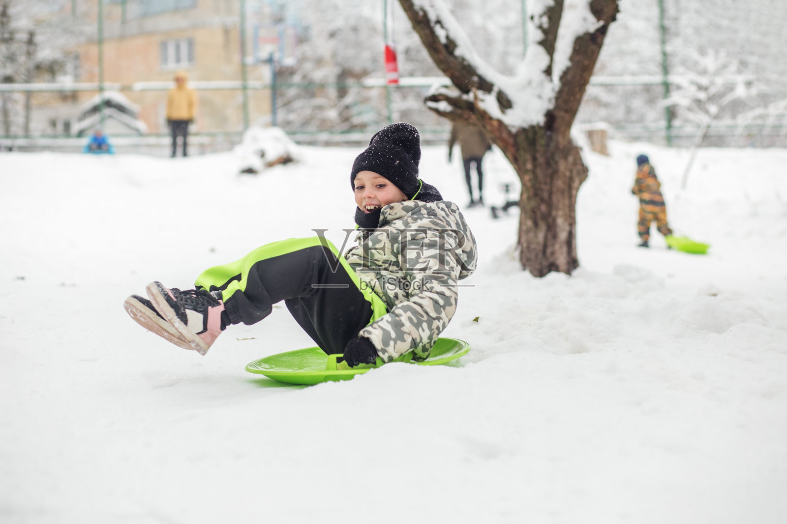 小女孩骑在雪板上。户外玩耍。寒冷的温度。冬天照片摄影图片