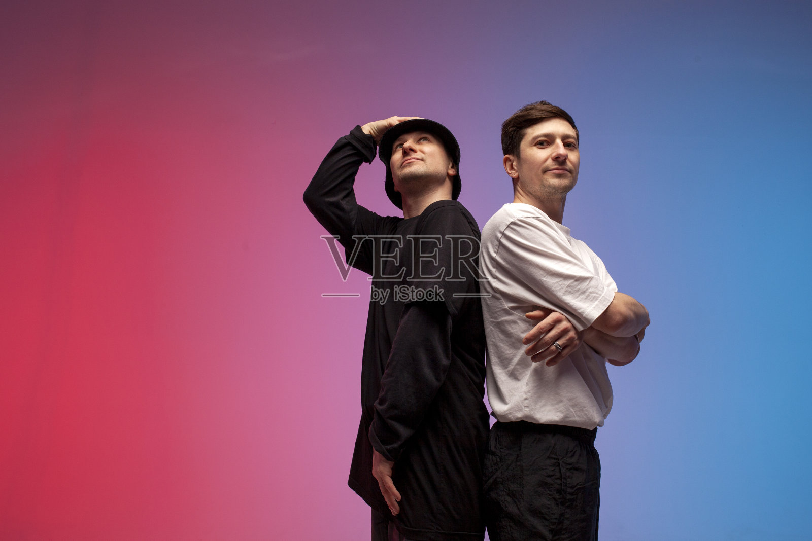 两个舞女在夜总会的霓虹灯下站在一起，男说唱歌手站在红蓝背景上照片摄影图片