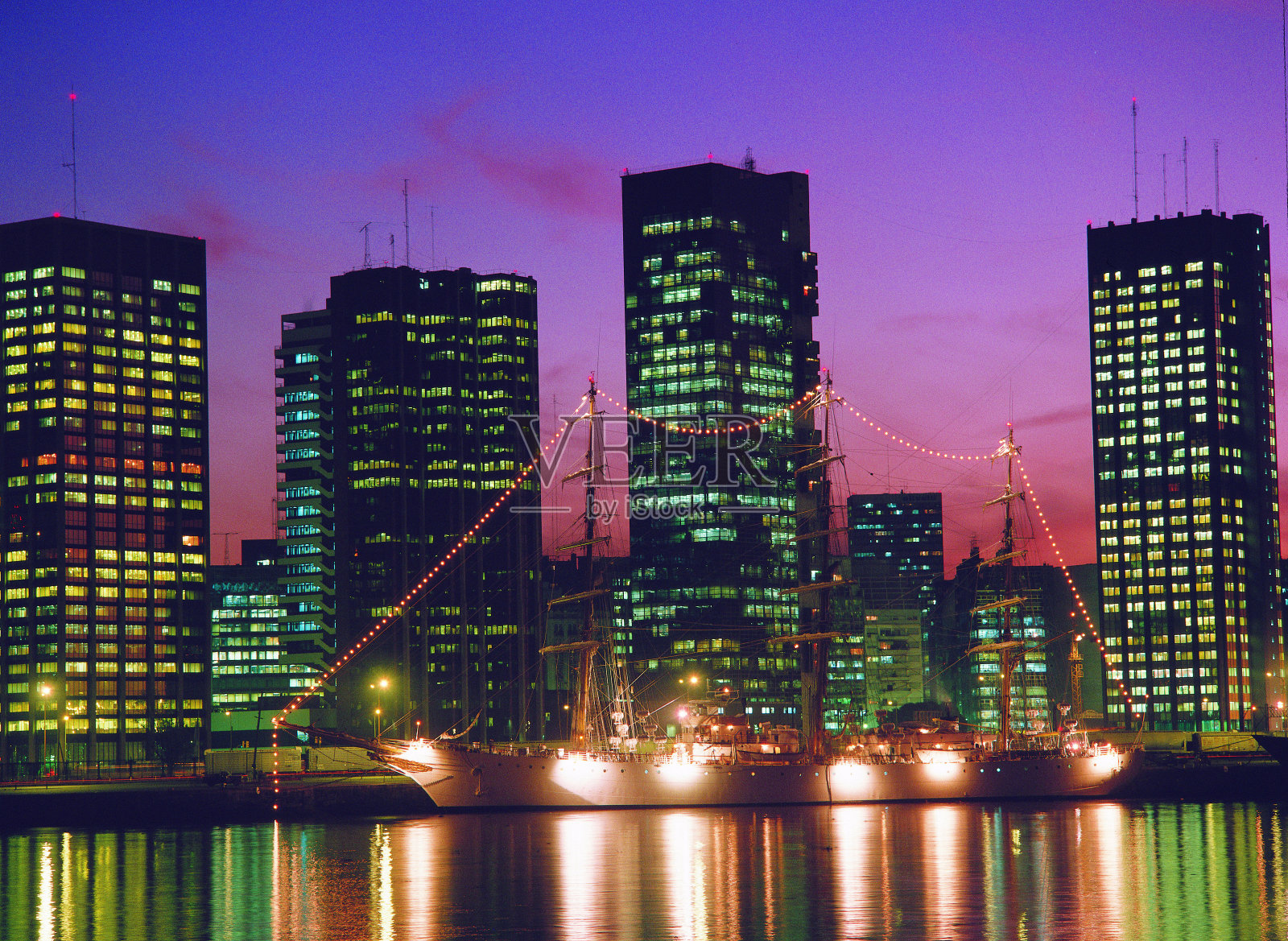 阿根廷布宜诺斯艾利斯马德罗港的自由号护卫舰被摩天大楼照亮照片摄影图片