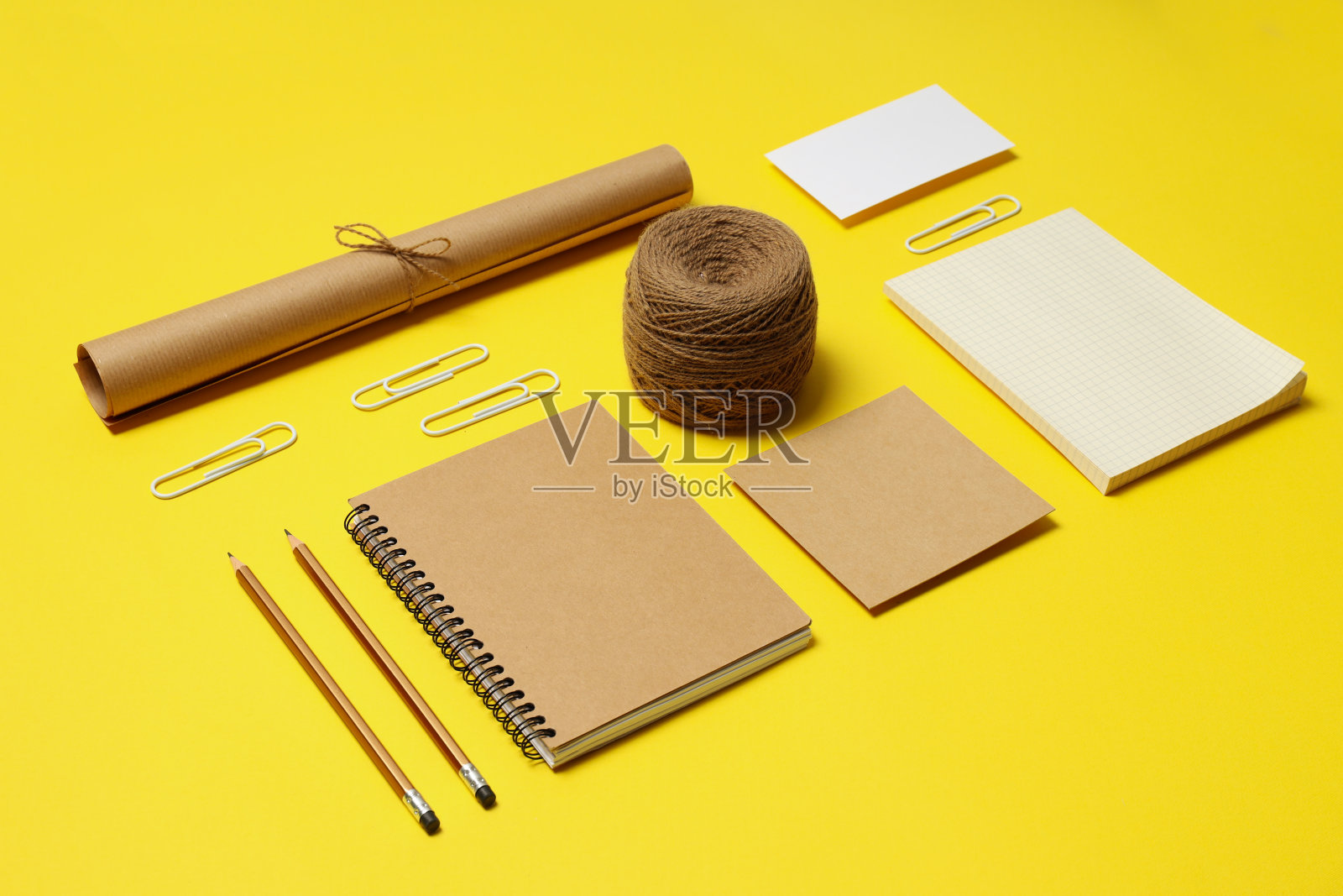 在黄色的背景上摆放着不同的办公配件照片摄影图片