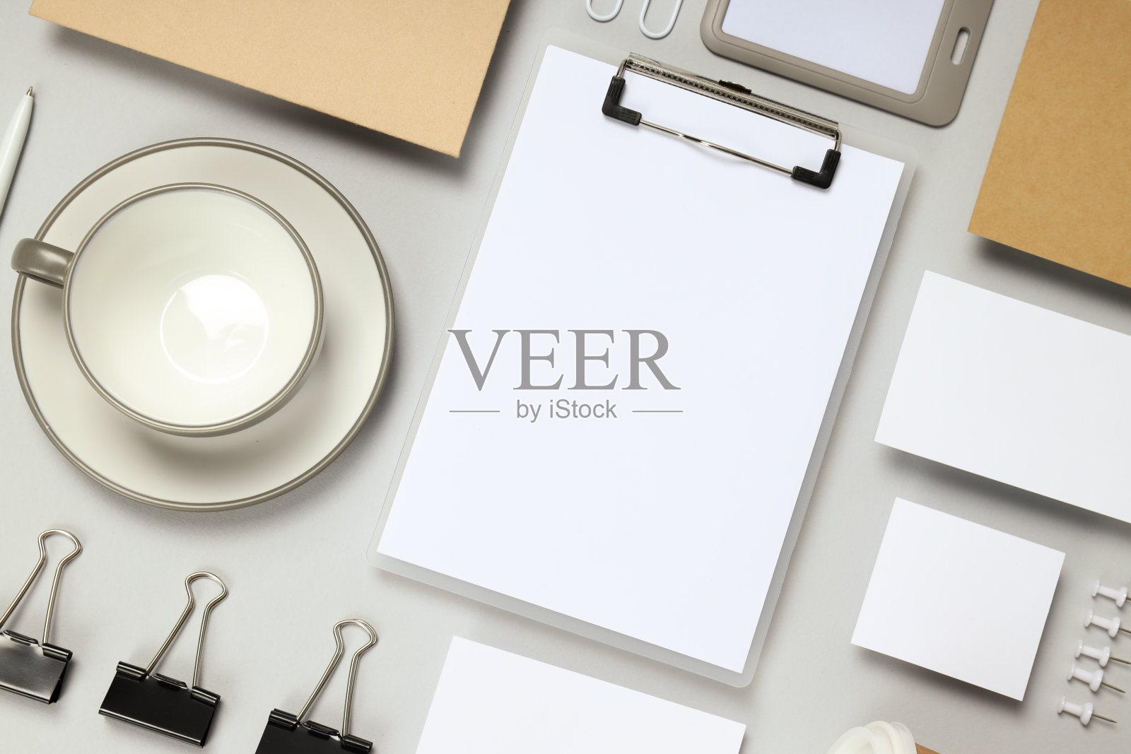 在浅灰色的背景下，以不同的办公配件为背景的平面模型照片摄影图片