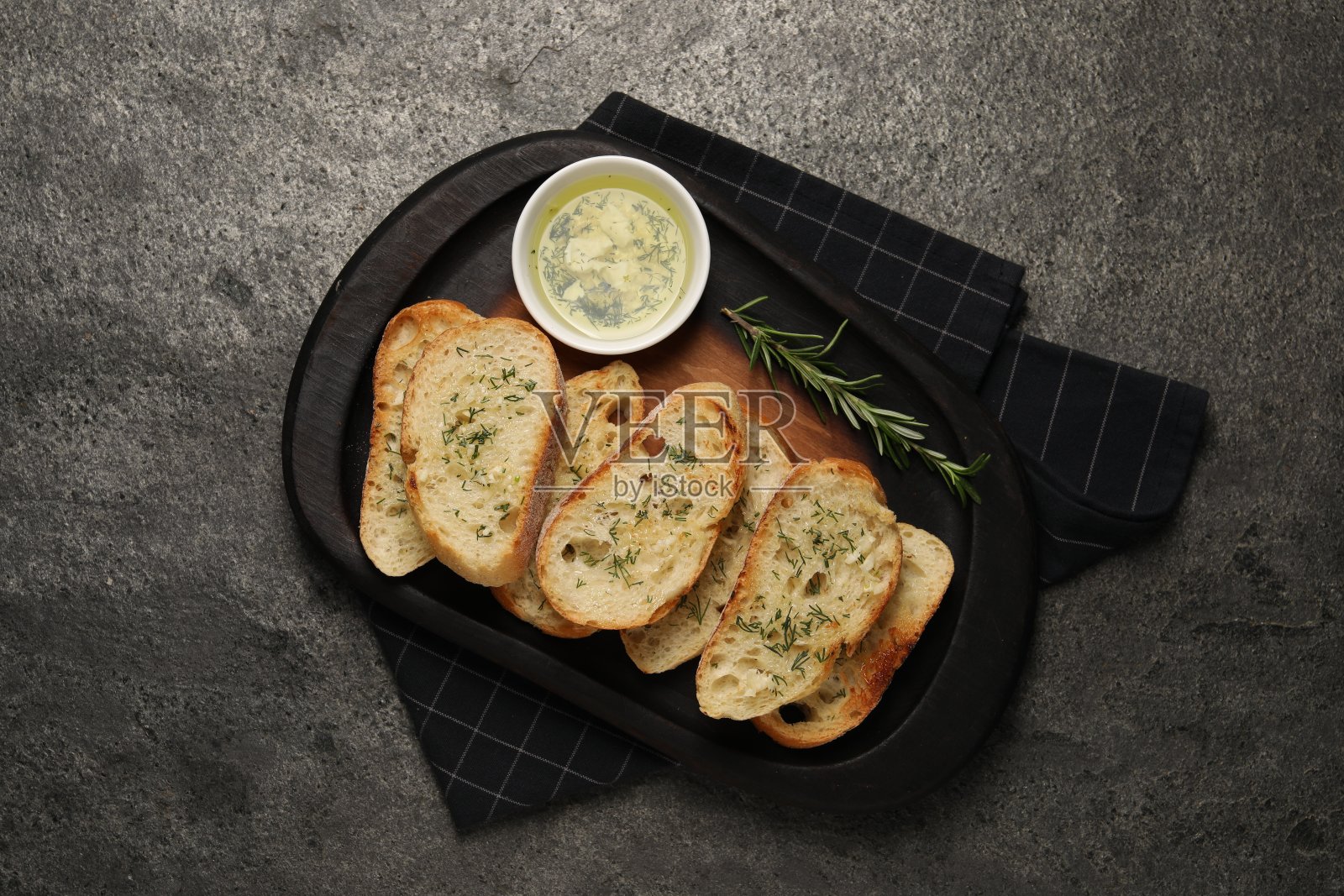 美味的法棍面包与大蒜和莳萝上灰色纹理的桌子，俯视图照片摄影图片