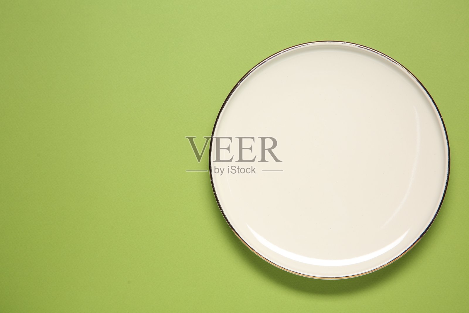 一个绿色背景的白色盘子，俯视图。文本空间照片摄影图片