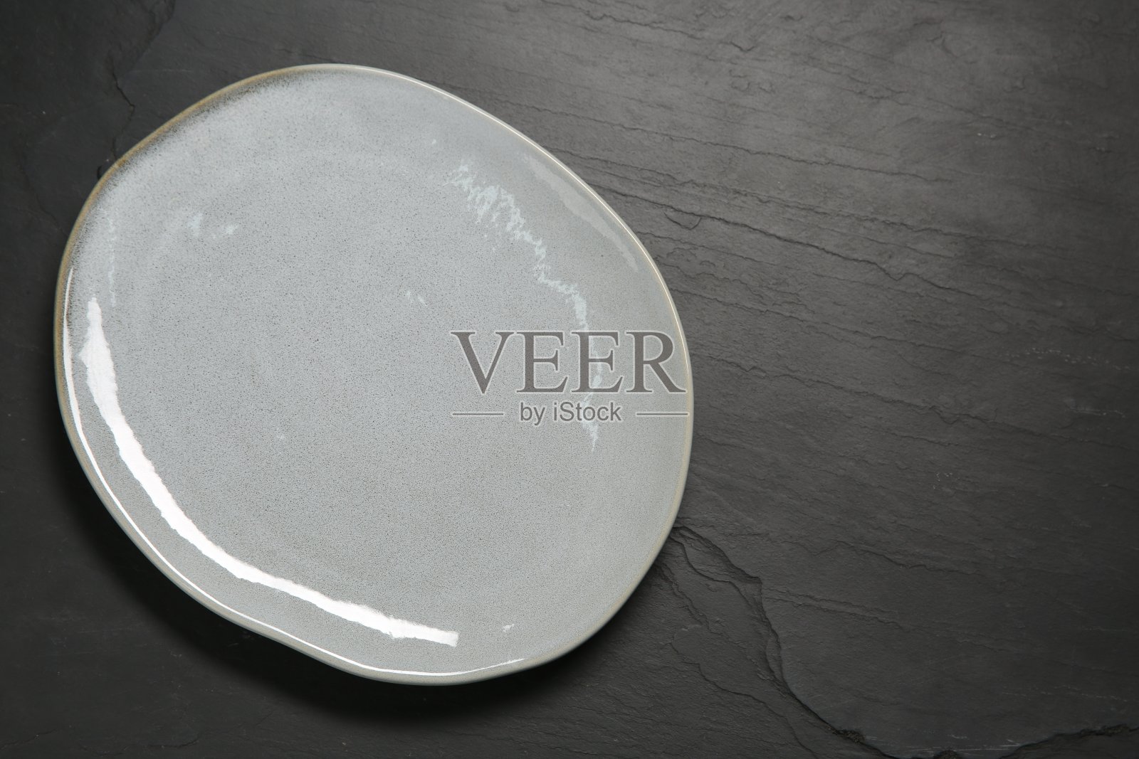 一个陶瓷板在黑色纹理表，顶视图。文本空间照片摄影图片