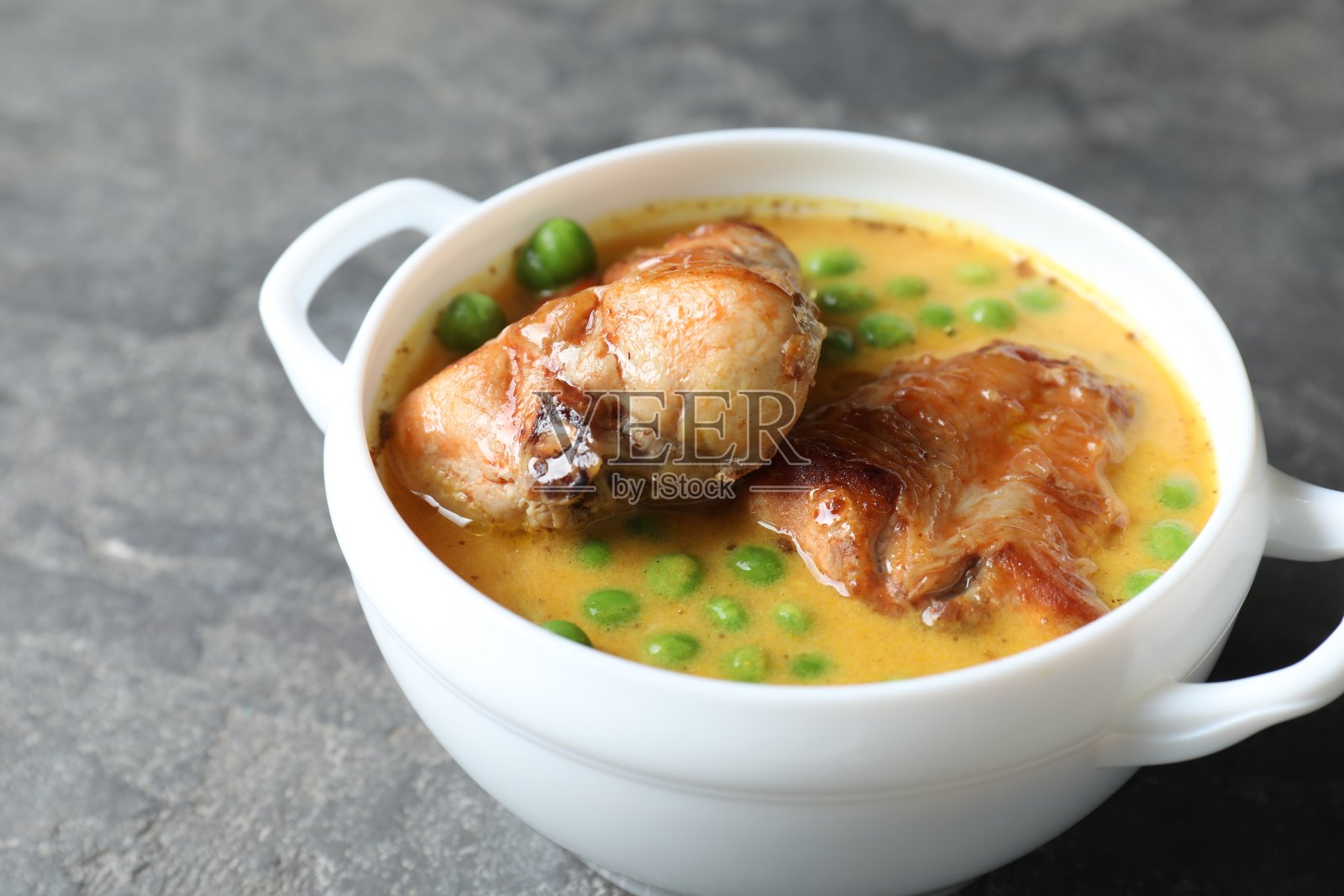 灰色餐桌上美味的兔肉配上酱汁和豌豆，特写照片摄影图片