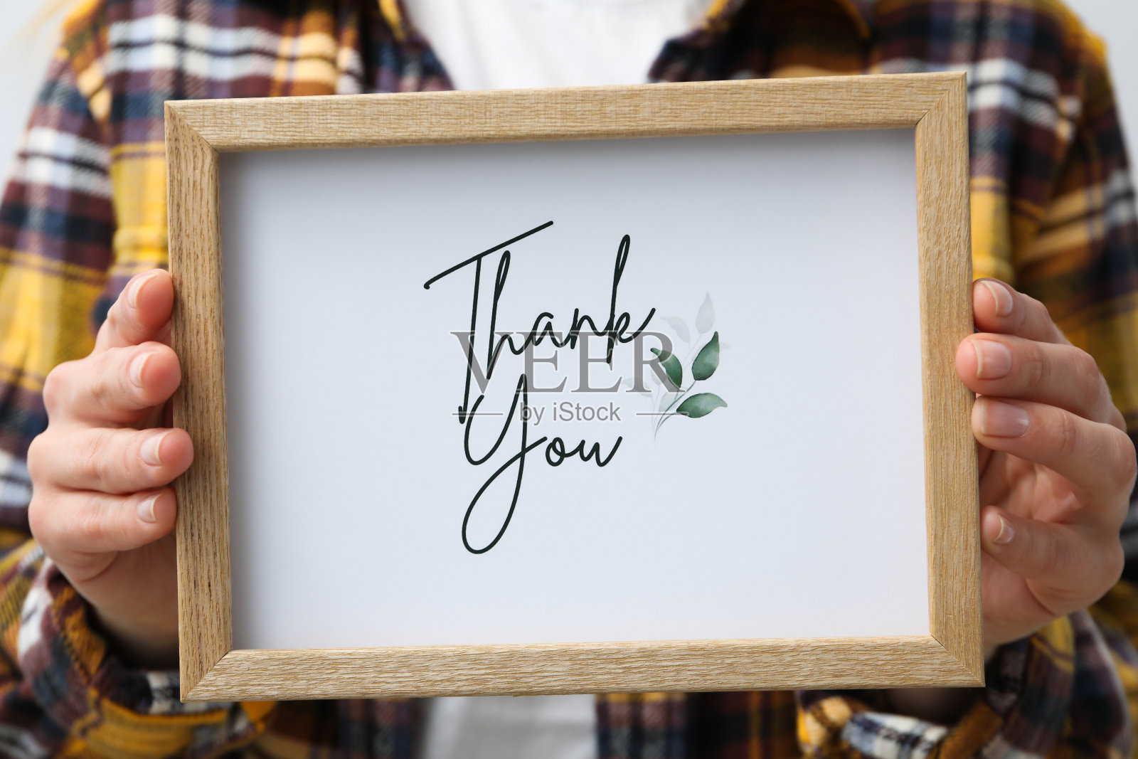 女士手里拿着木框，纸上写着“谢谢”字样照片摄影图片