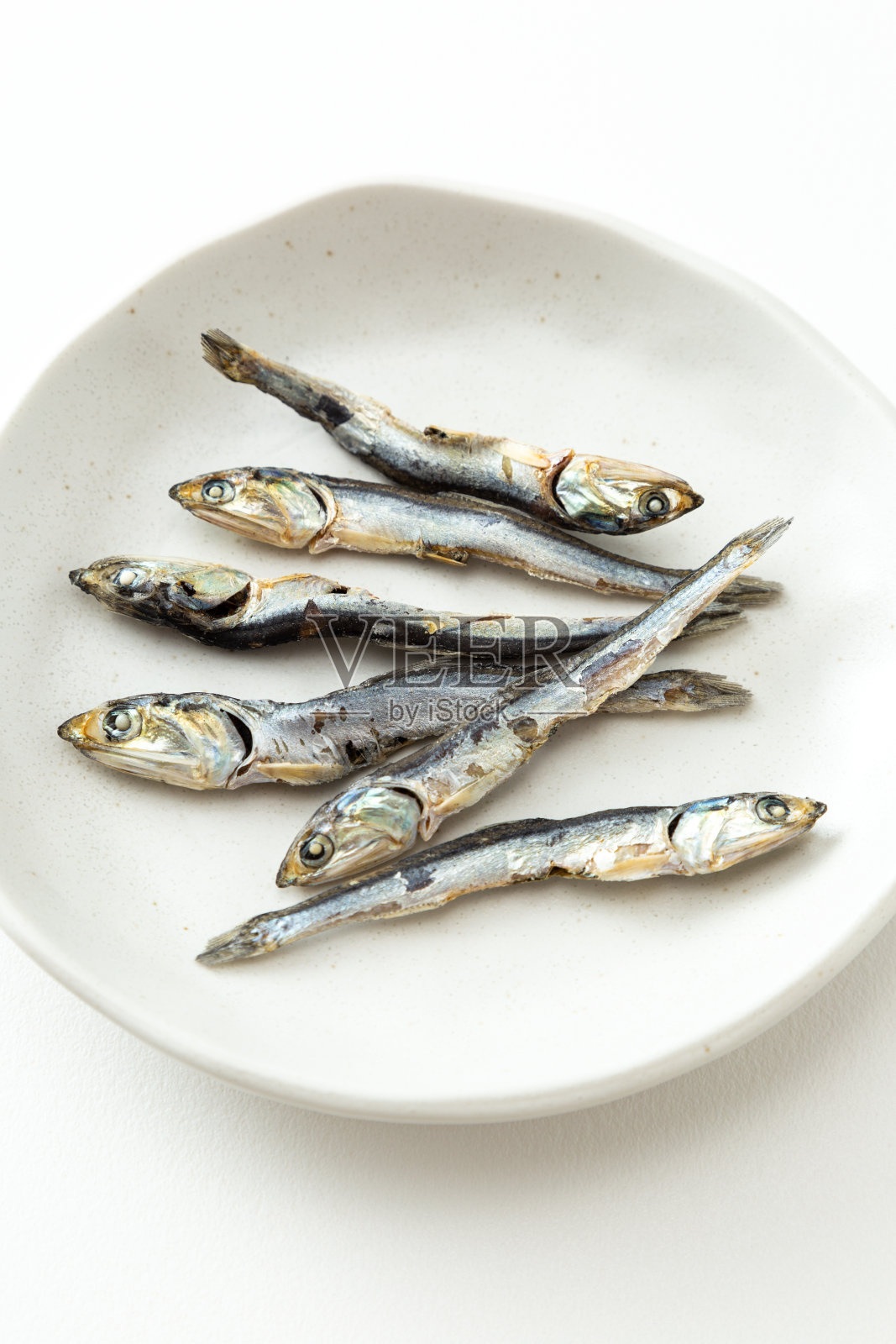 白色背景上的干沙丁鱼。照片摄影图片