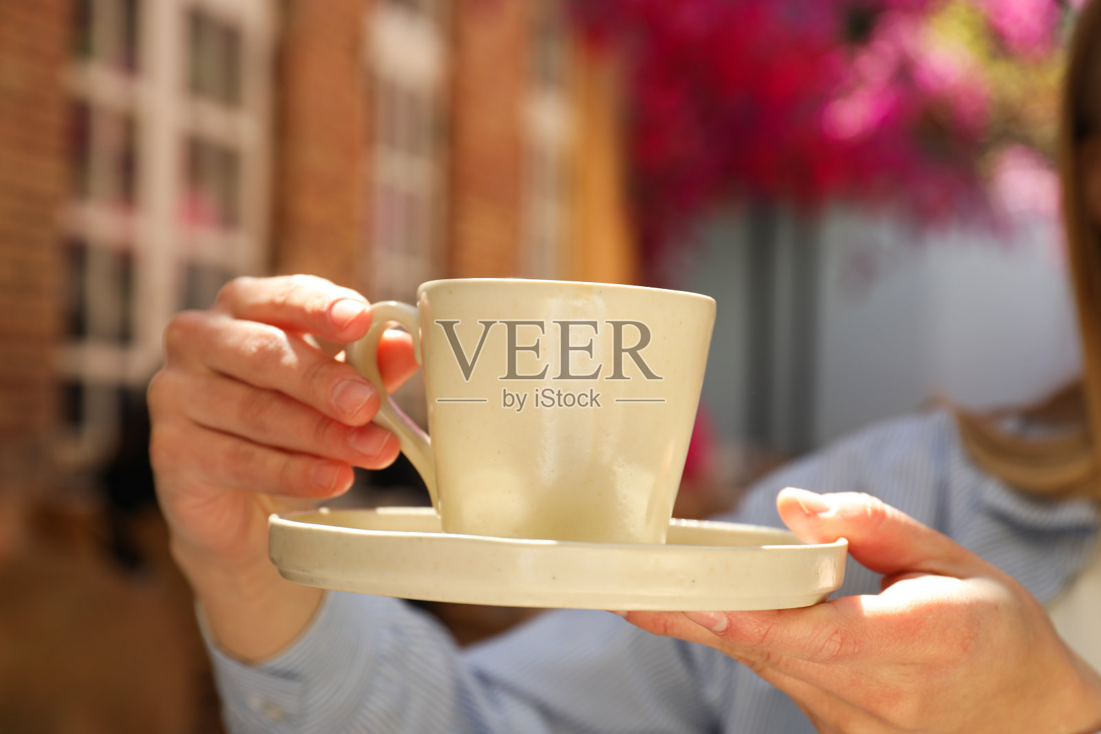 户外咖啡馆里，女性手中的杯子，近距离拍摄照片摄影图片