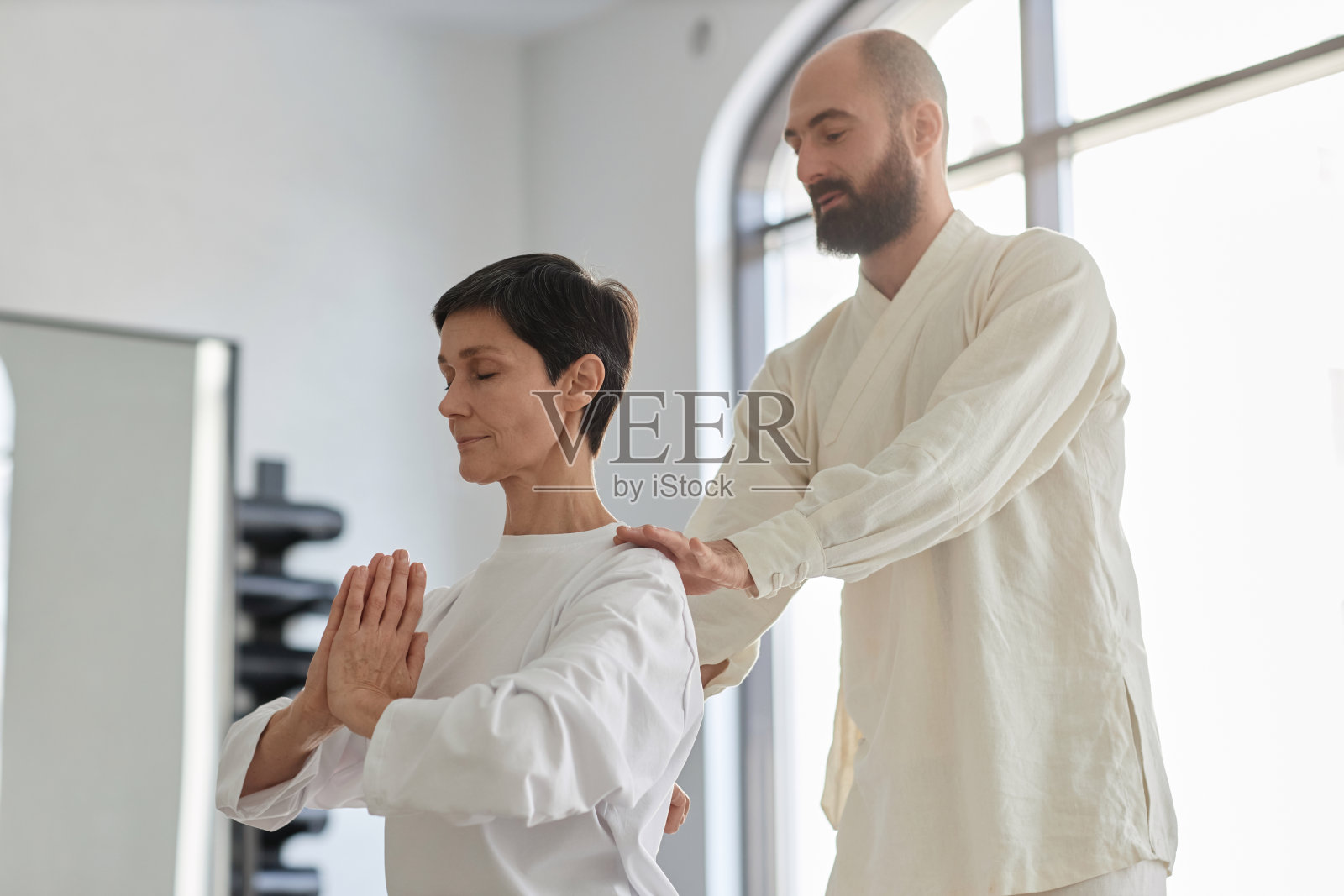 气功教练调整高年级女学员姿势照片摄影图片