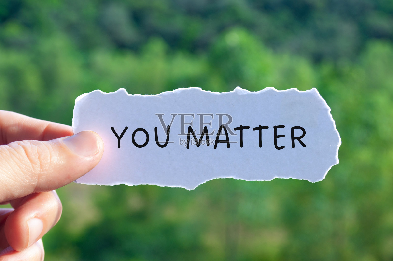 你用自然背景在撕破的白纸上书写文字。激励和鼓舞概念照片摄影图片