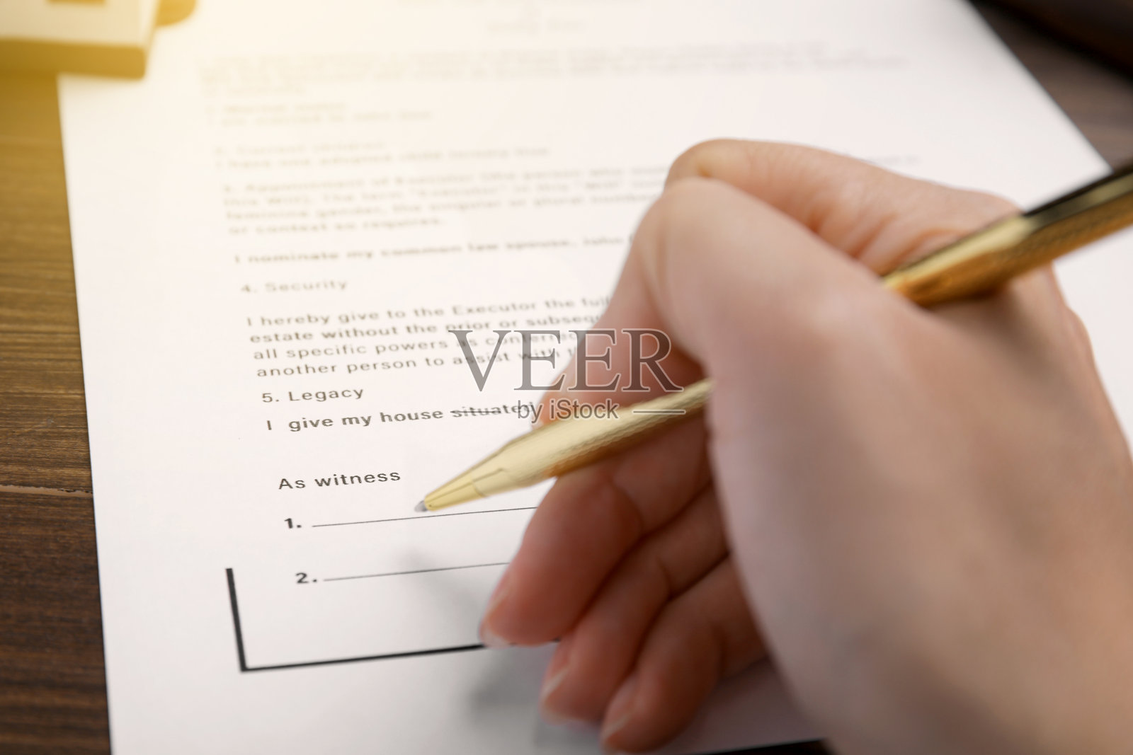 女人在餐桌上签署最后遗嘱，特写照片摄影图片