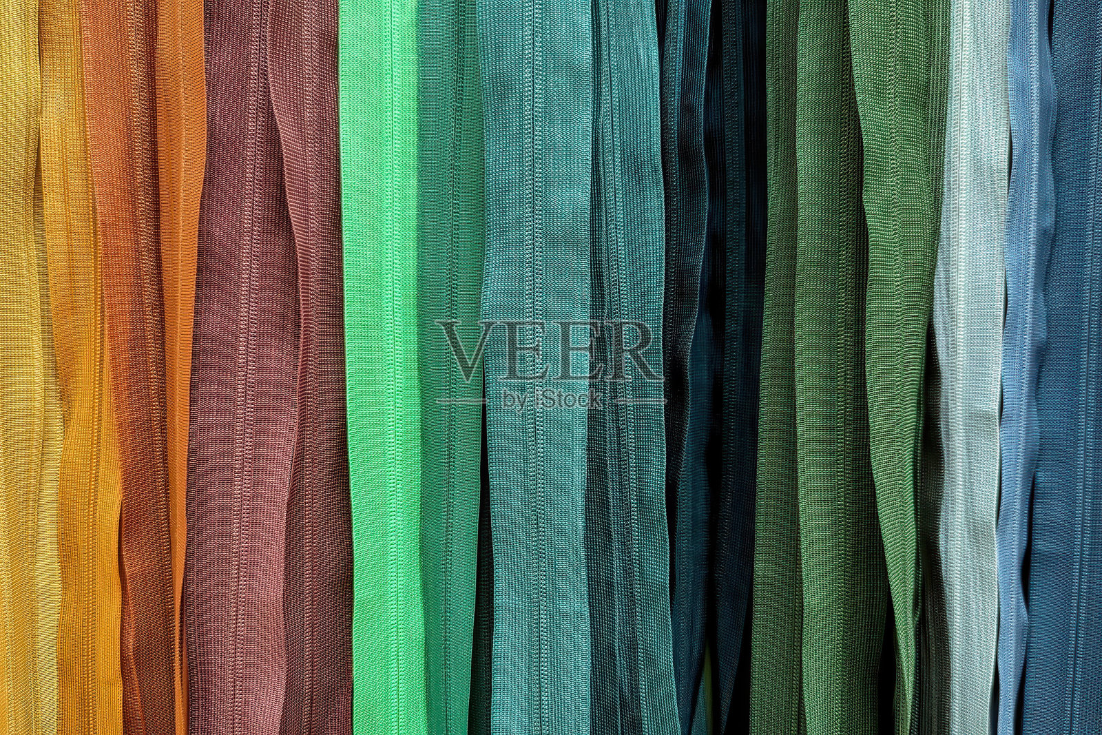 不同颜色的塑料拉链。各种YKK尼龙拉链。这是本季最热门的颜色。照片摄影图片