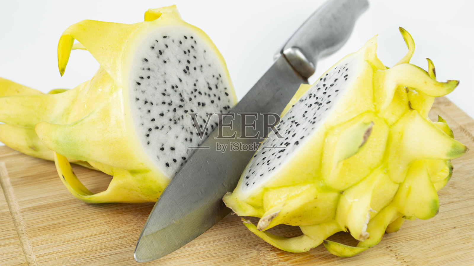 一个亮黄色的火龙果切成两半。照片摄影图片