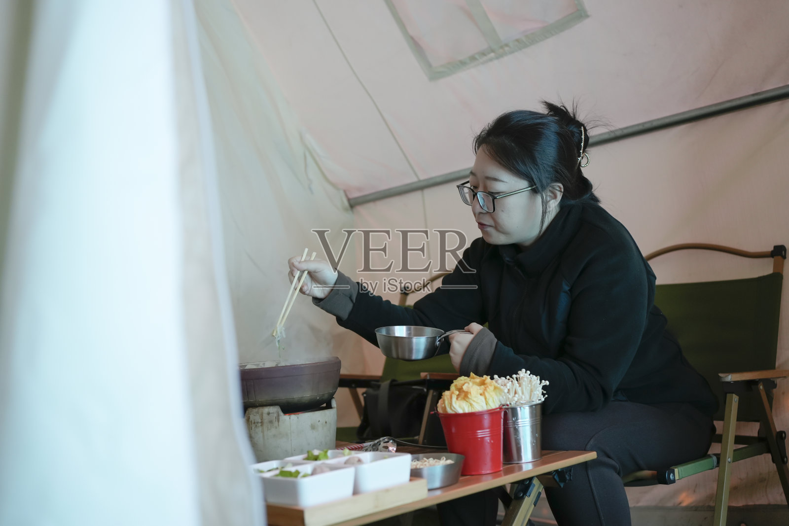 年轻的妇女们正在帐篷里野餐照片摄影图片