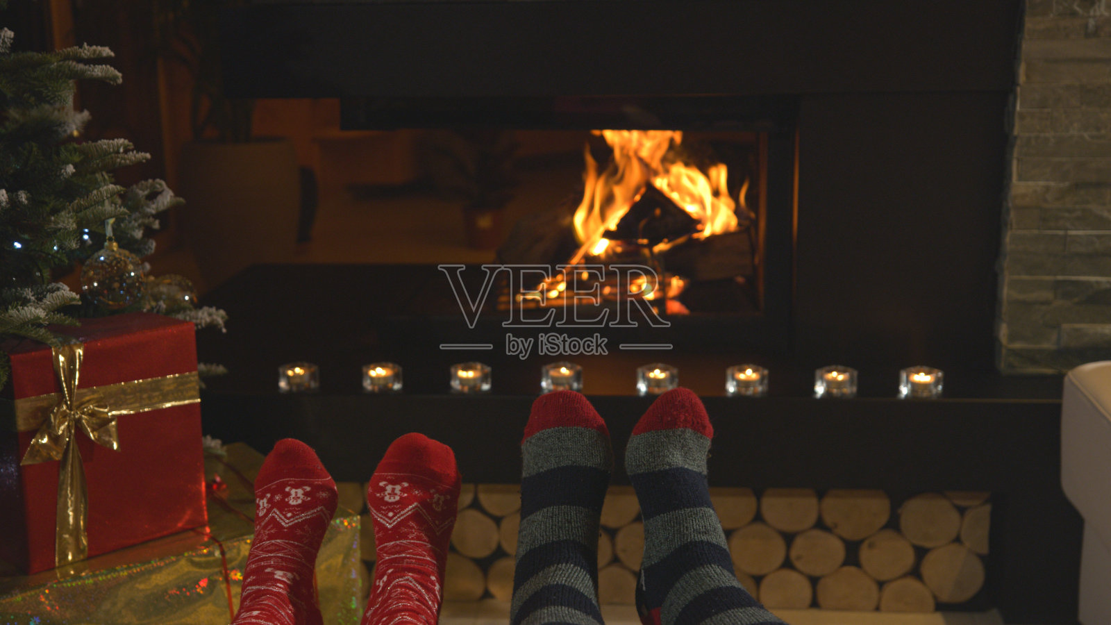 一对夫妇在壁炉边休息，穿着圣诞袜暖脚照片摄影图片