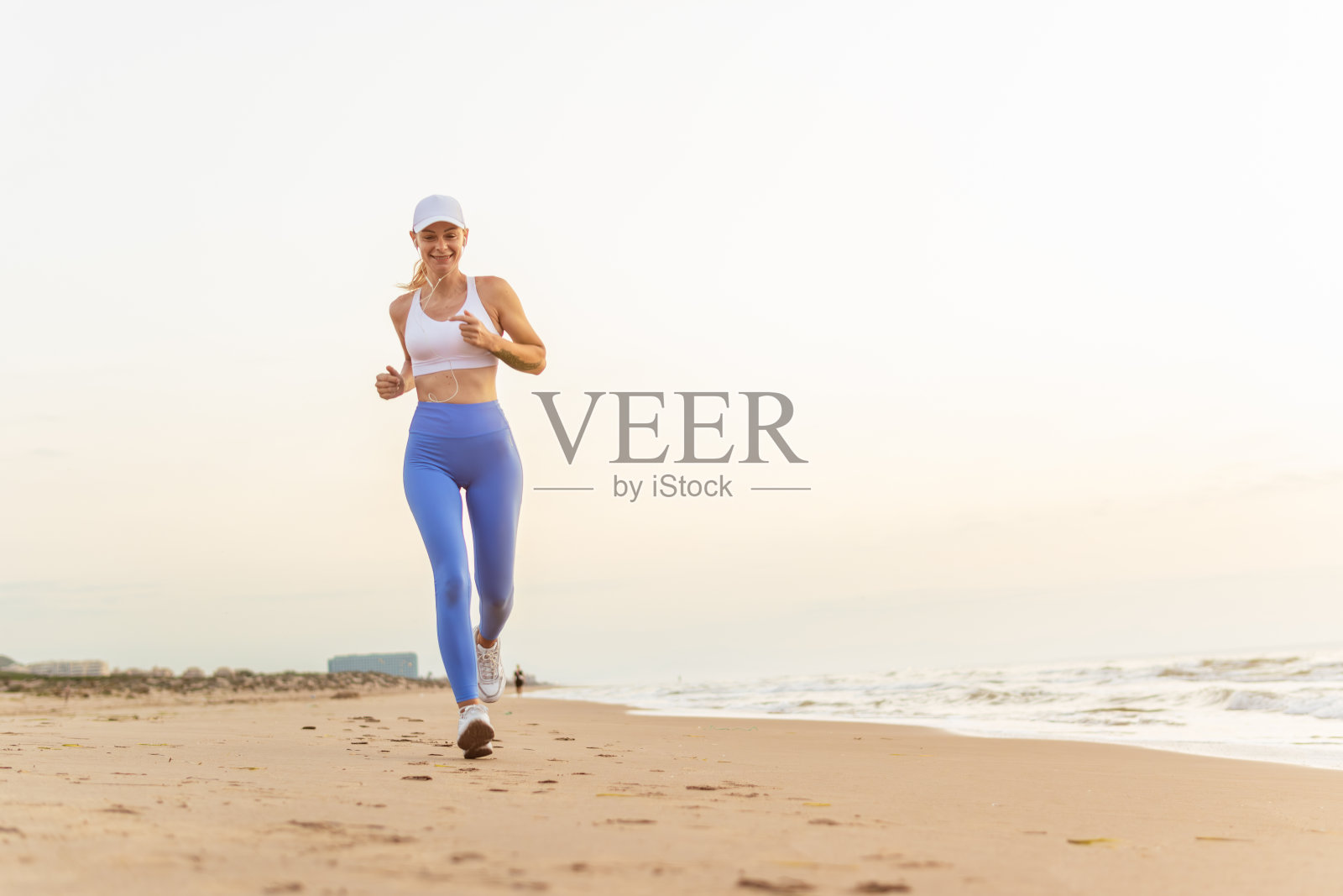 美丽的运动女人沿着美丽的沙滩奔跑，健康的生活方式，享受海边积极的暑假。高质量照片照片摄影图片