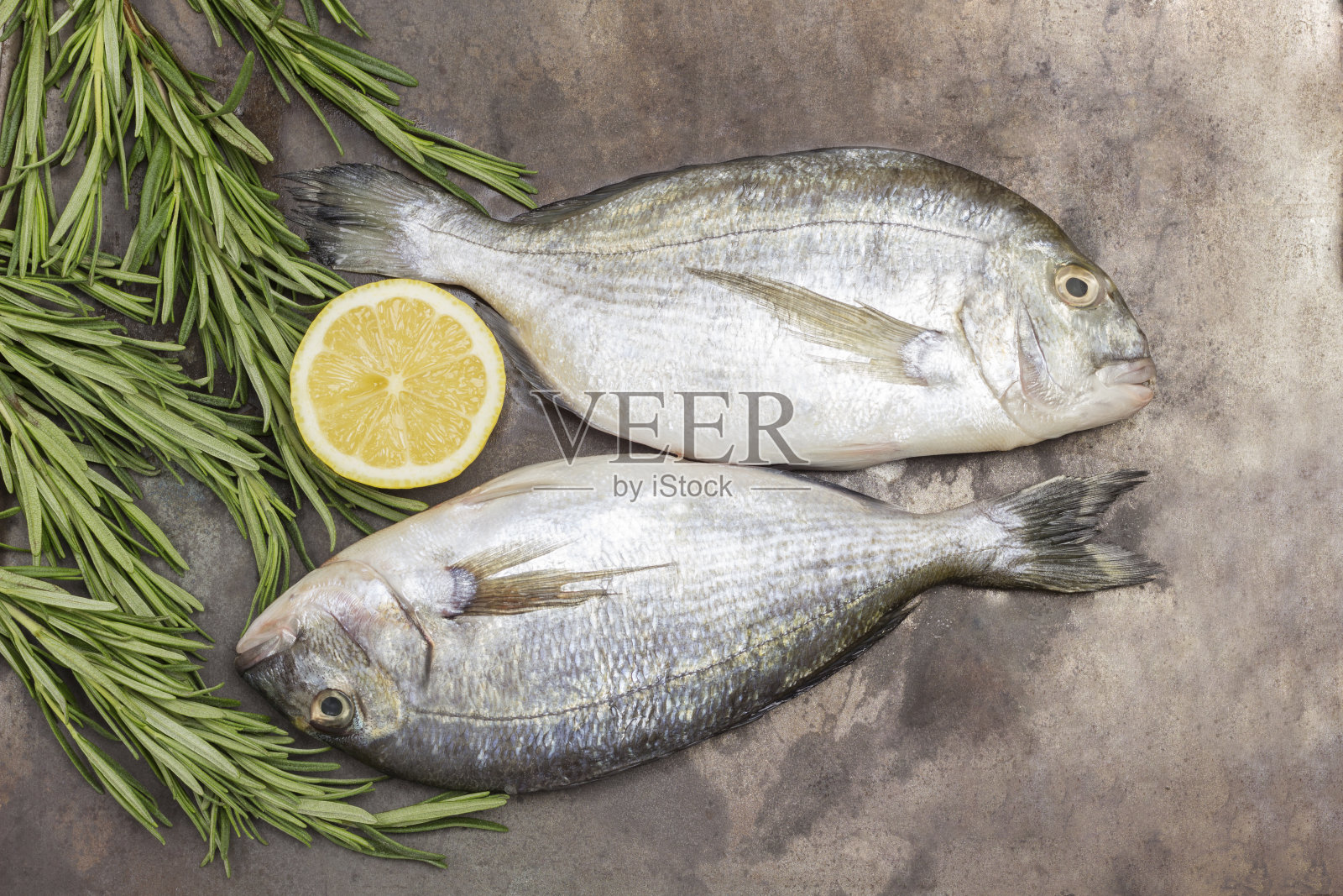 生鱼配柠檬和迷迭香。照片摄影图片