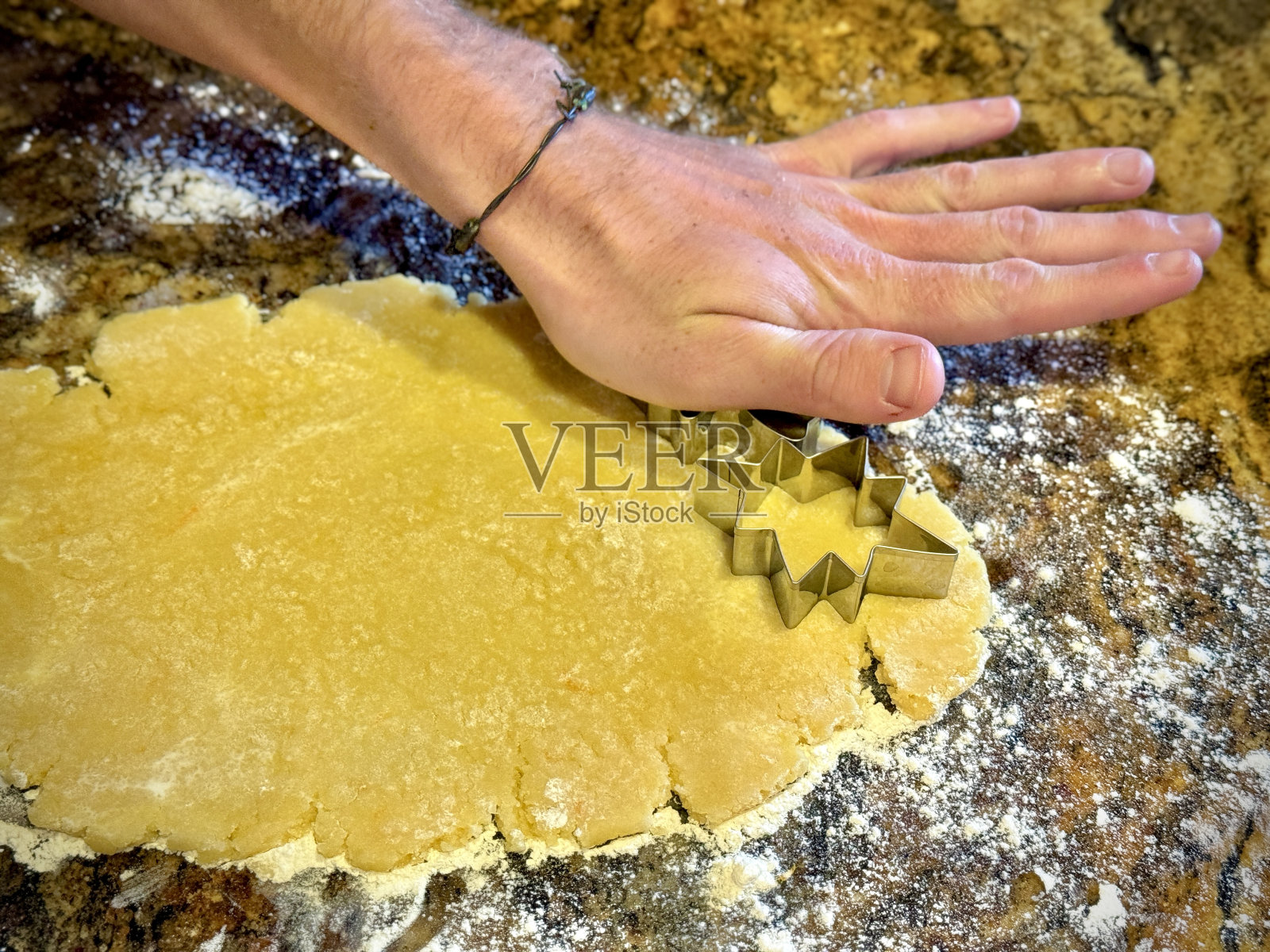 122323手压饼干切割机在擀好的面团上照片摄影图片