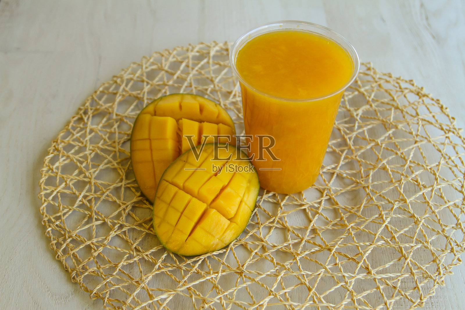新鲜的芒果汁服务于一次性玻璃隔离在桌子侧面的健康的早晨果汁饮料照片摄影图片