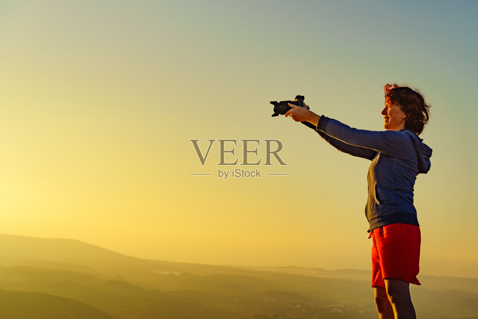 女人拿着相机拍旅行照照片摄影图片