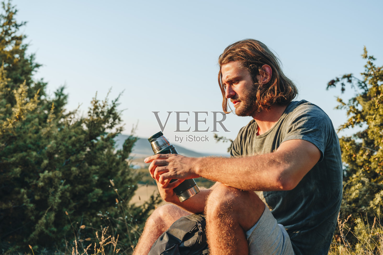 一名徒步旅行者在乡村徒步旅行时坐在岩石上休息照片摄影图片