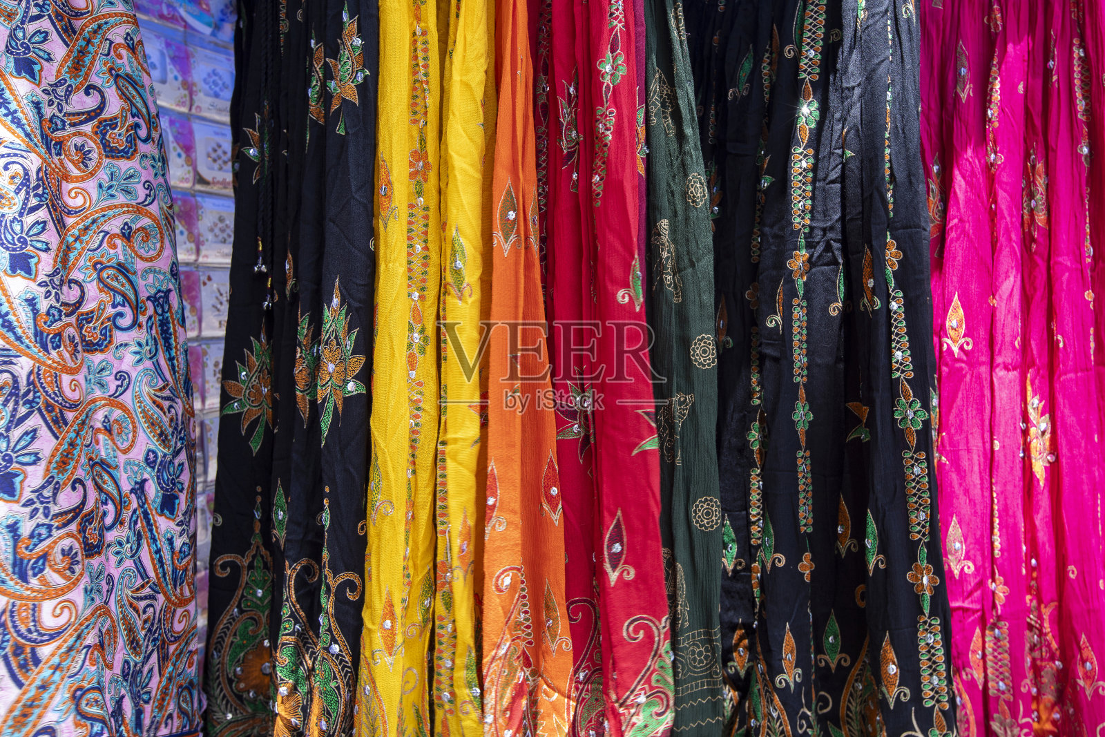 嬉皮士集市上的街市上挂着五颜六色的传统服饰。照片摄影图片