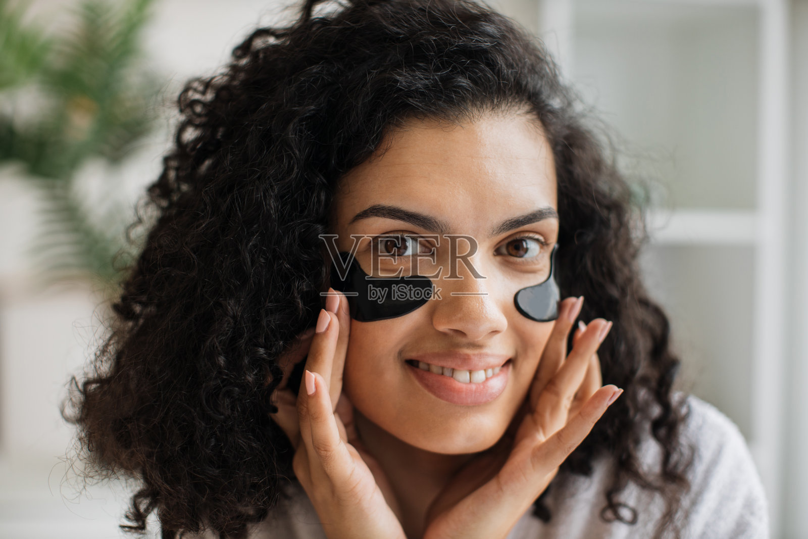 穿着白色浴袍的非洲女性正在戴着眼罩照片摄影图片