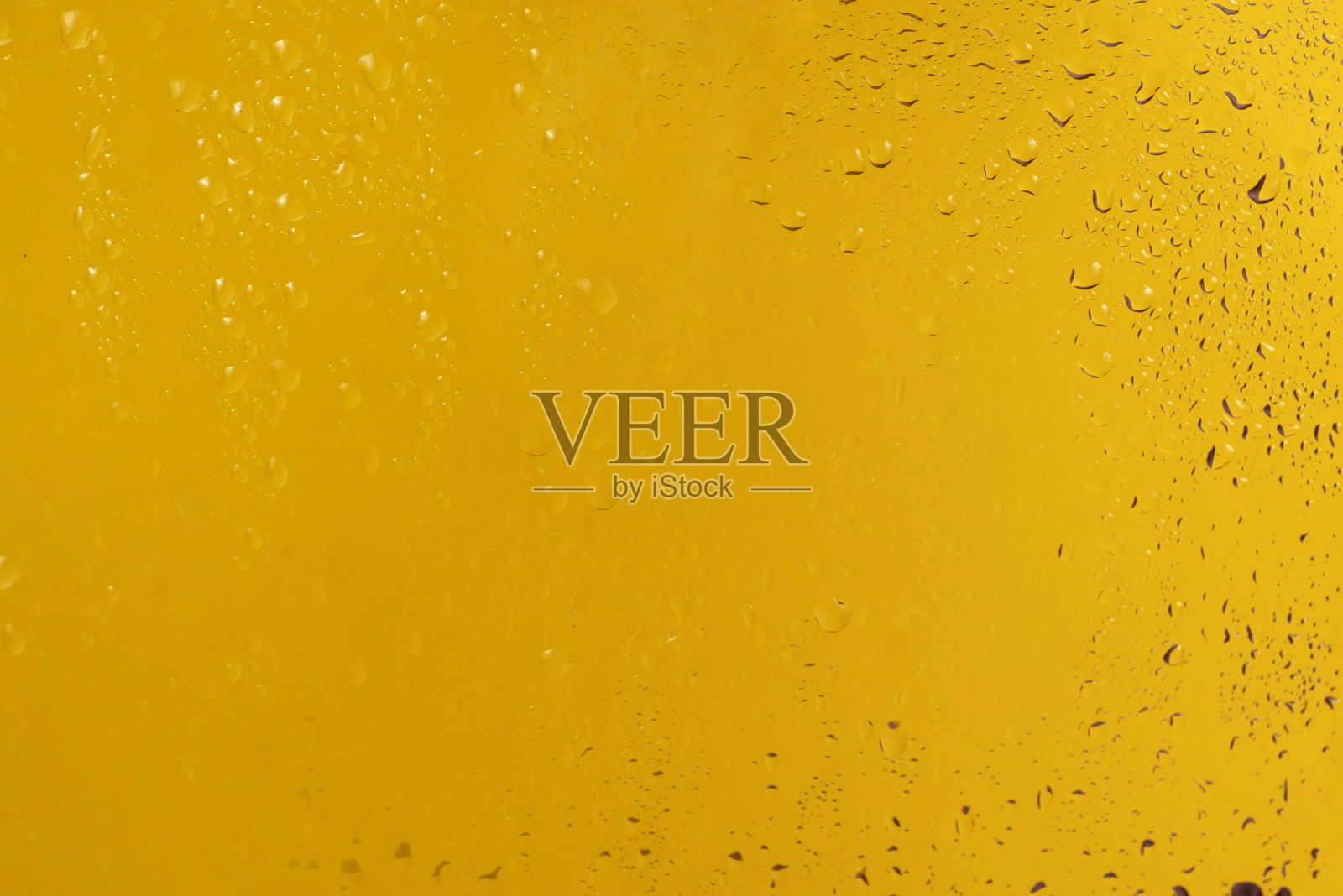 黄色背景与水滴。照片摄影图片