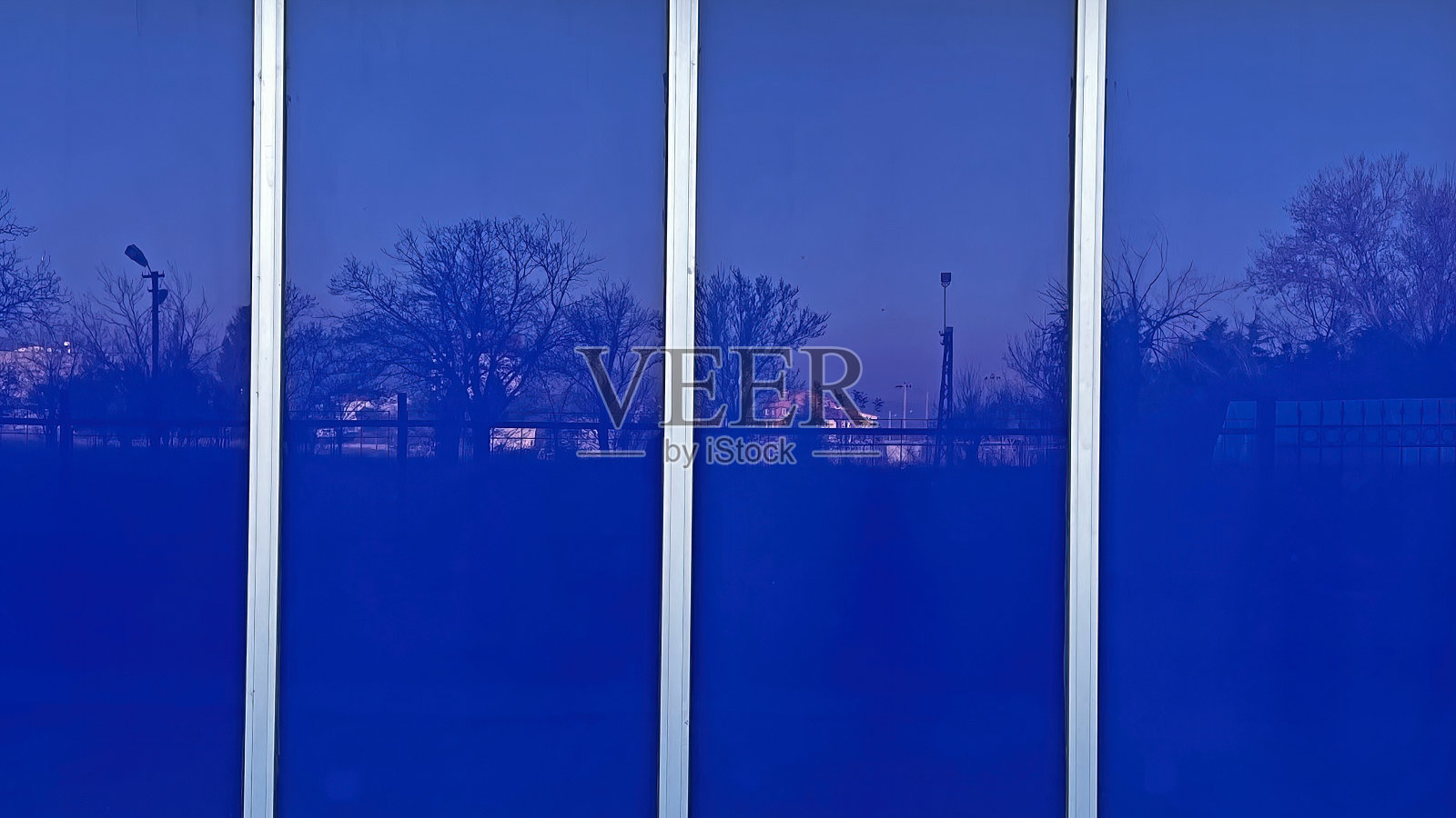 建筑物的蓝色窗户反射出的景色。照片摄影图片