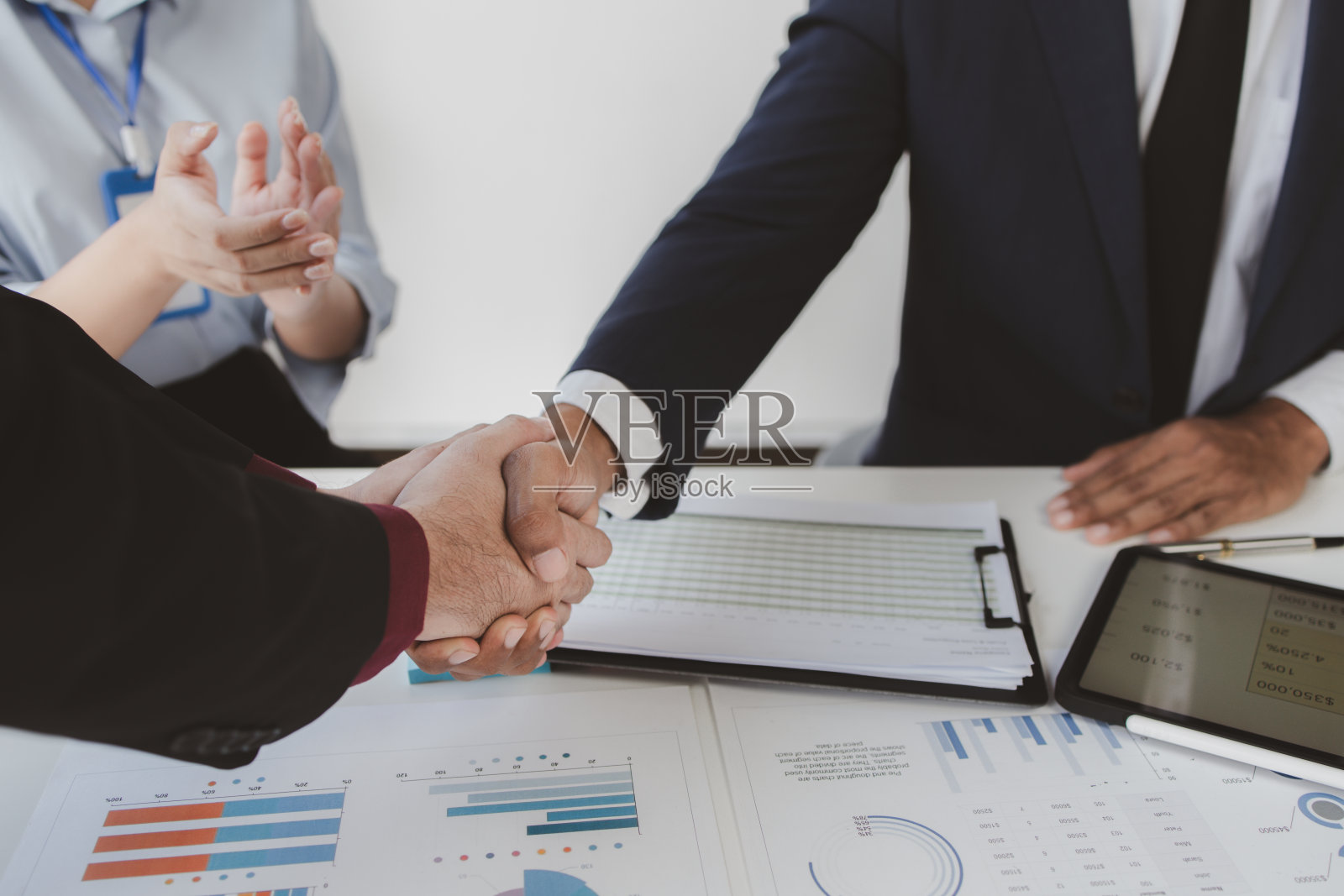 商务投资团手牵着手，洽谈成功后，两位商人正在洽谈业务，并握手。握手是西方的问候或祝贺方式。照片摄影图片