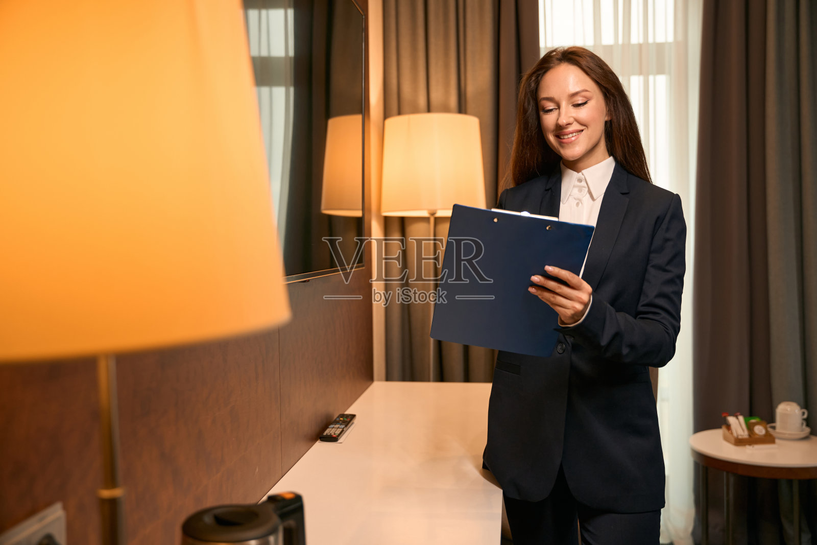 欢乐经理在客房清洁后检查时做记录照片摄影图片